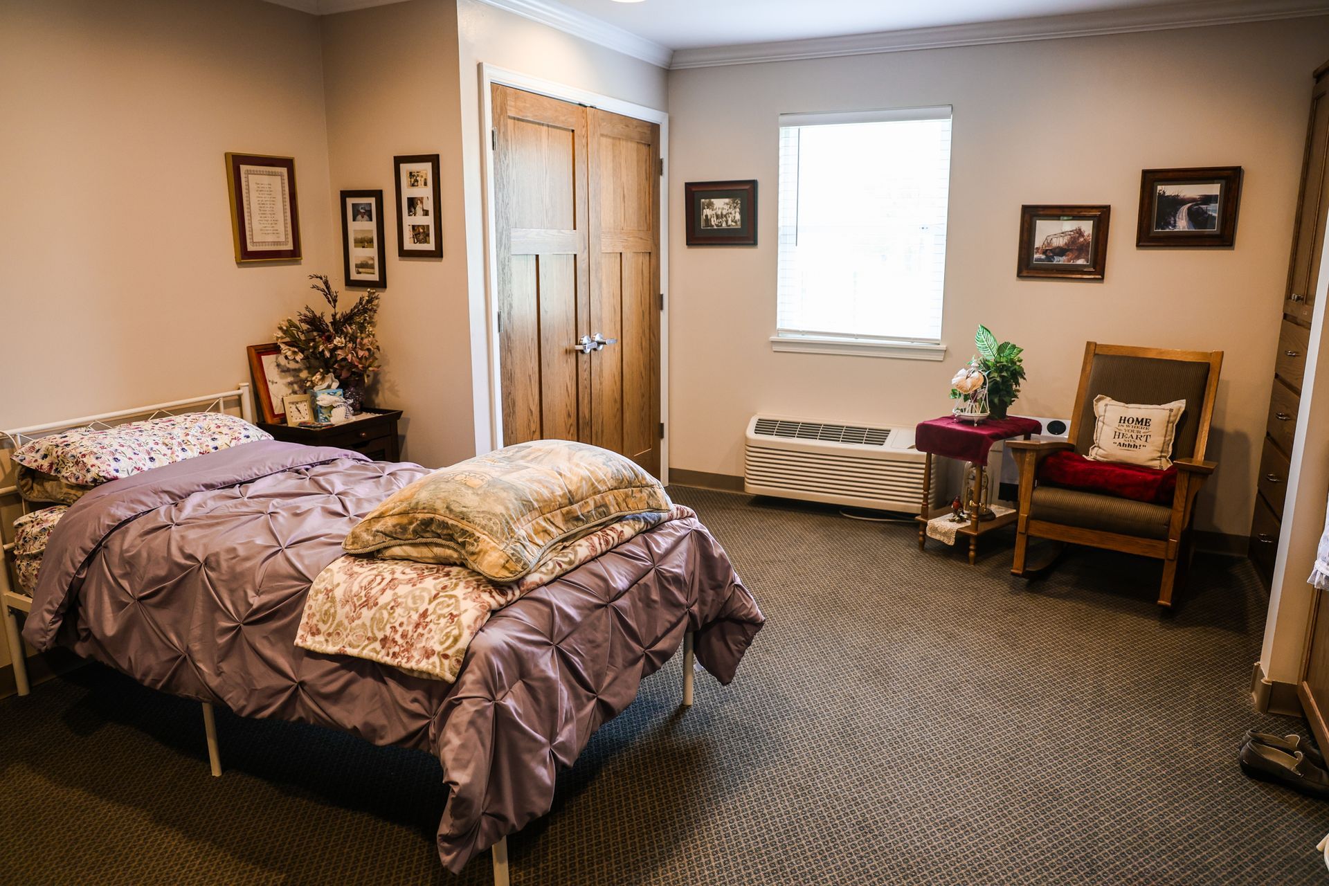 A bedroom with a bed , chair , table and window.