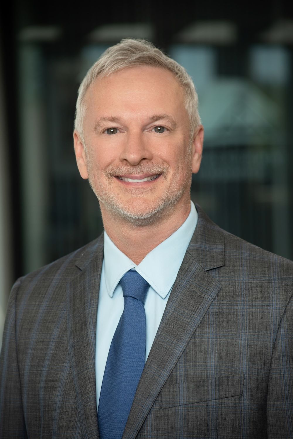 A man and a woman are shaking hands in an office.