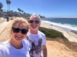 A man and a woman are standing next to each other on a beach.