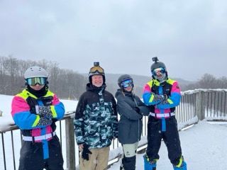 A group of people are standing next to each other in the snow.