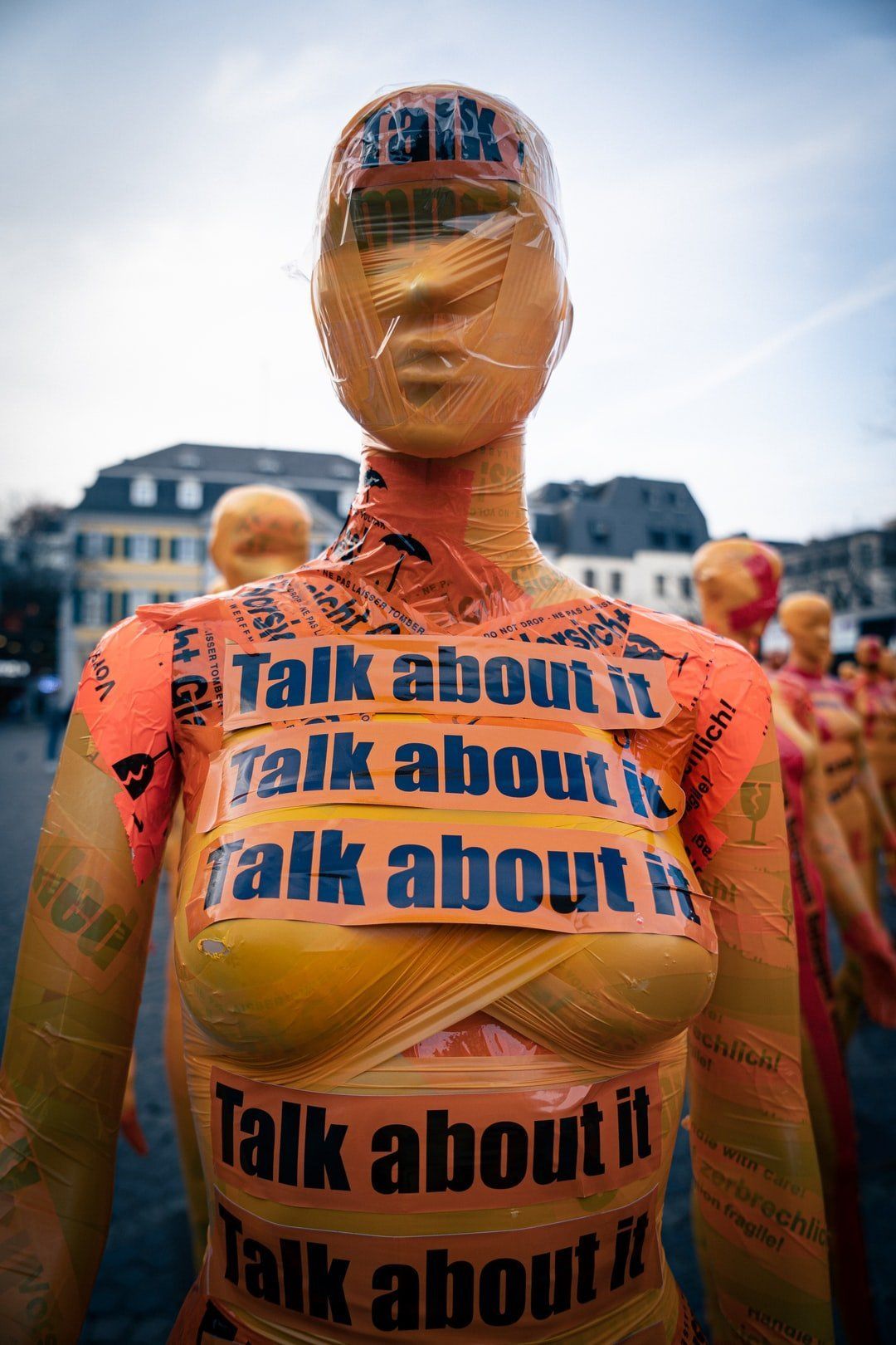 Picture of woman wrapped in messages saying talk about it in regards to sexual assault and rape