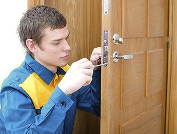 Locksmith installing a new lock on a door