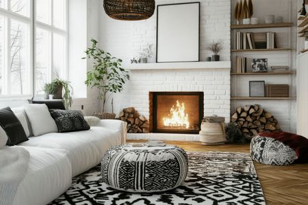 A living room with a fireplace , couch , rug and ottomans.