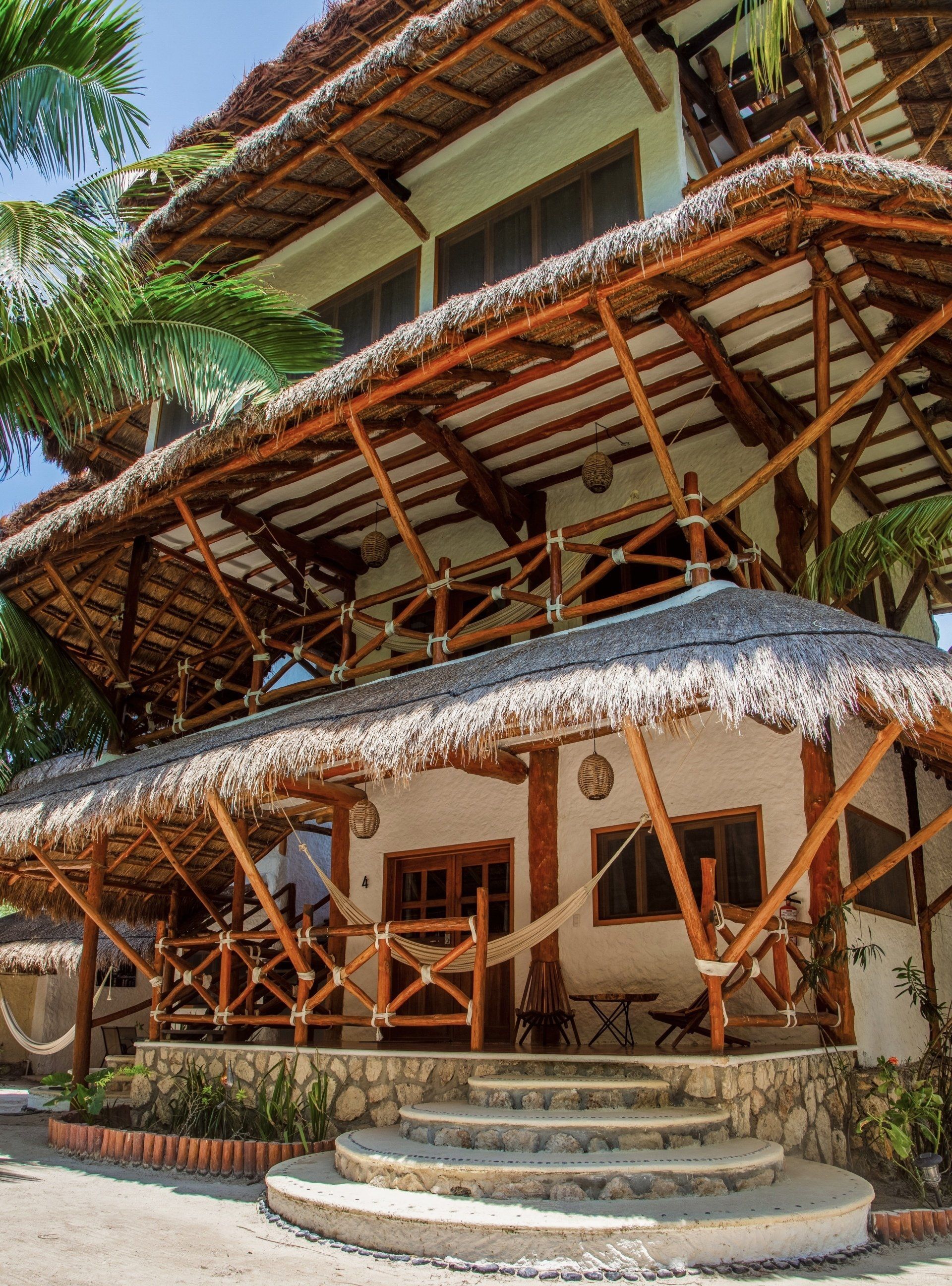 A thatched roofed building with stairs leading up to it