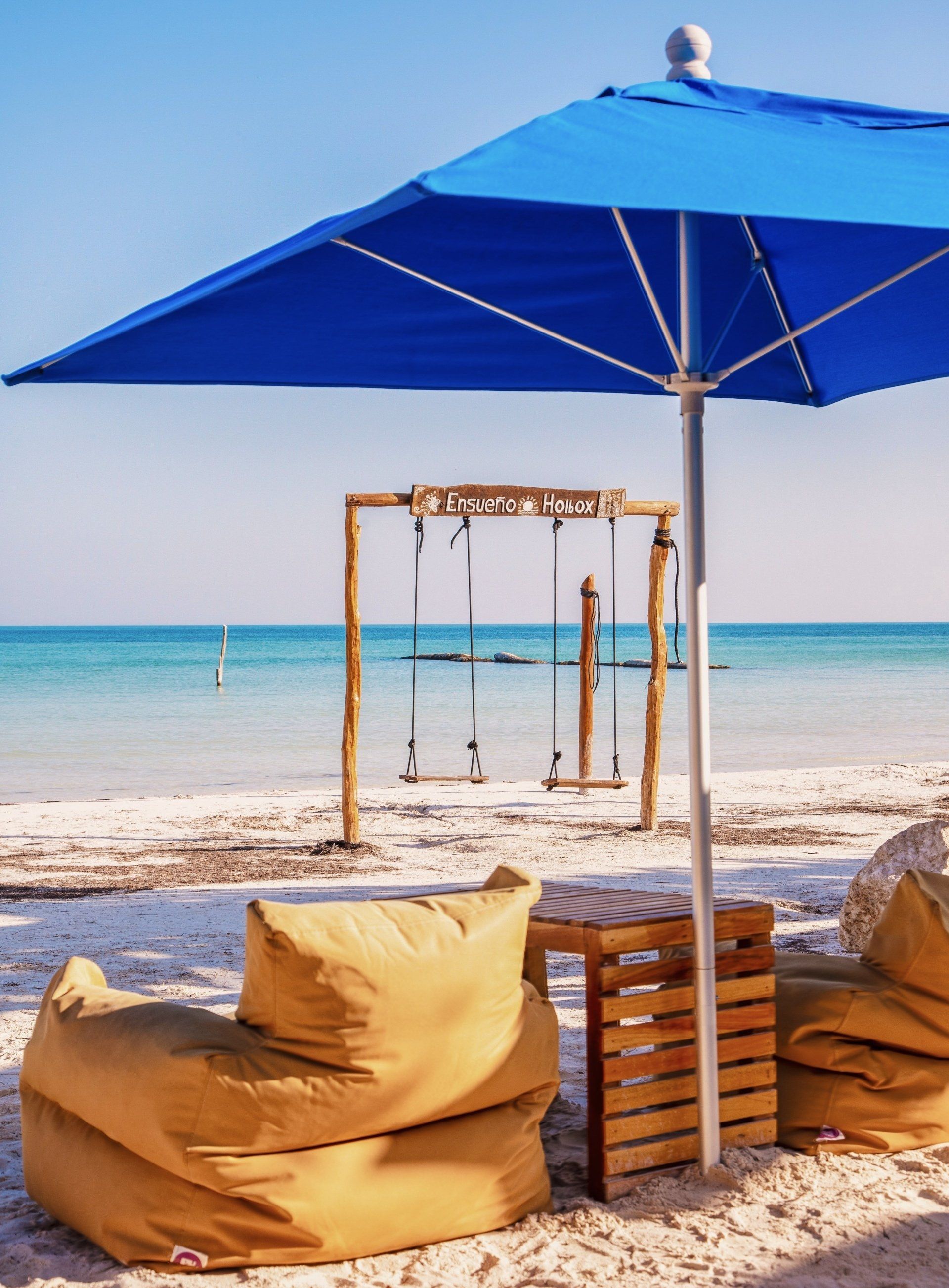 A blue umbrella is sitting on a sandy beach