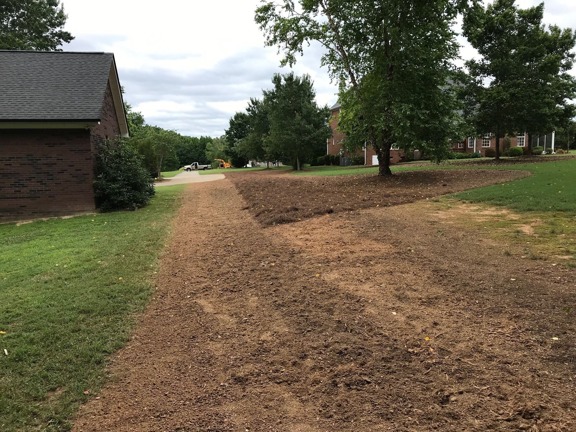 A dirt road leading to a house in a residential area