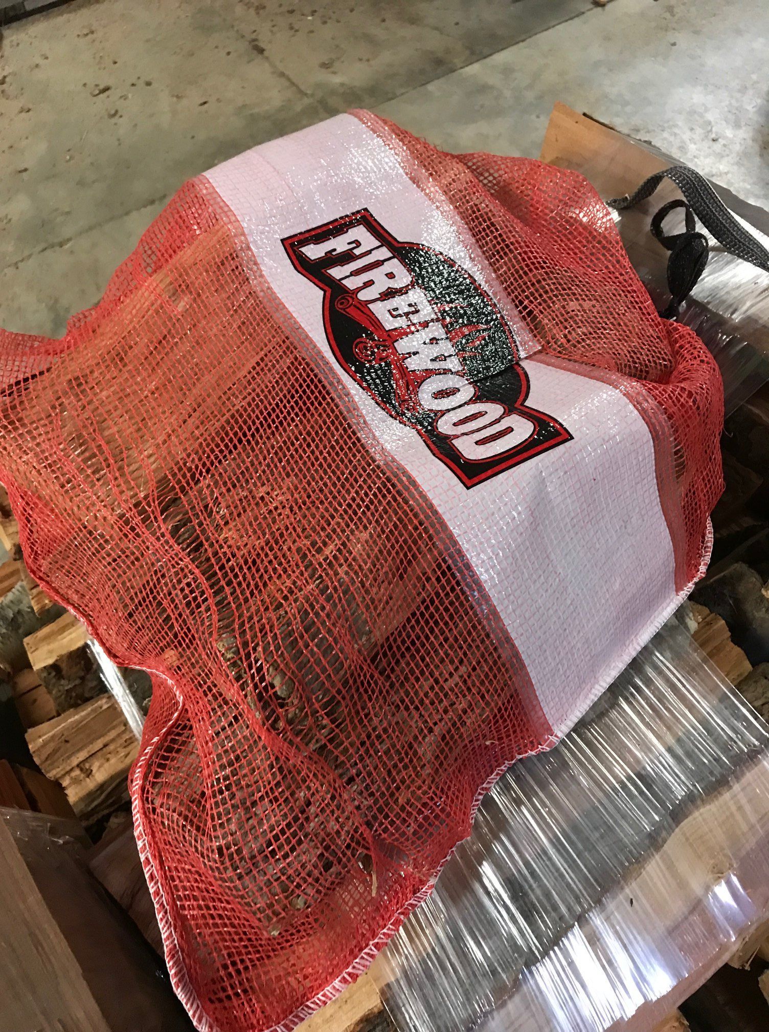 A bag of firewood is sitting on top of a pallet.