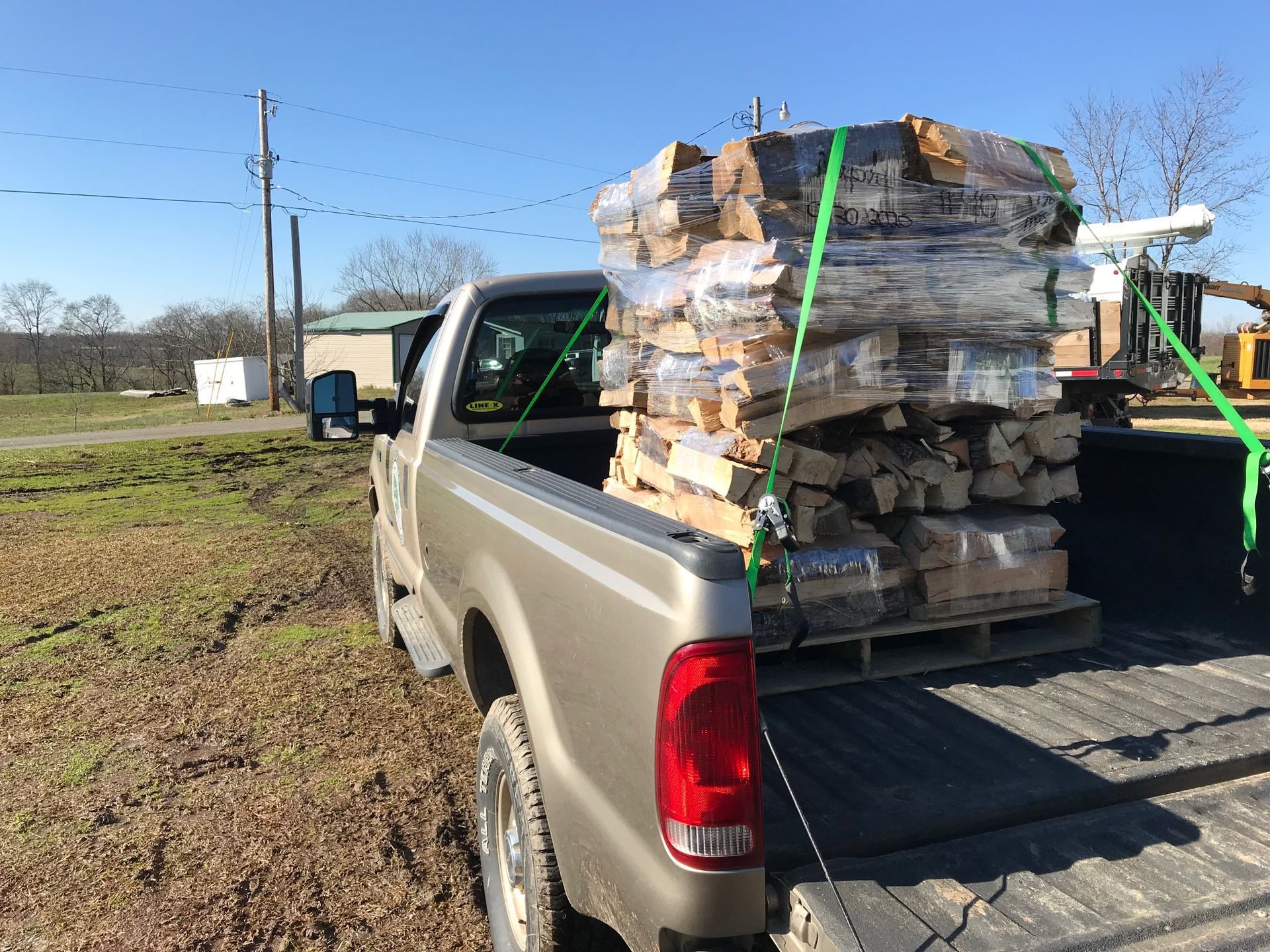 A truck is loaded with a large stack of wood.