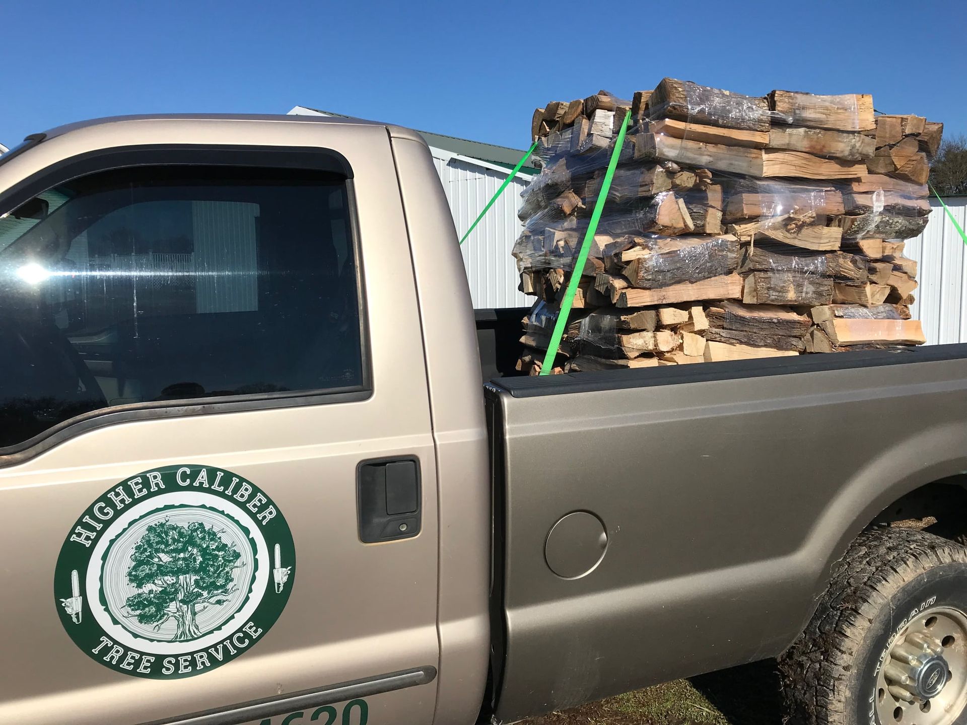 A higher caliber tree service truck is loaded with logs