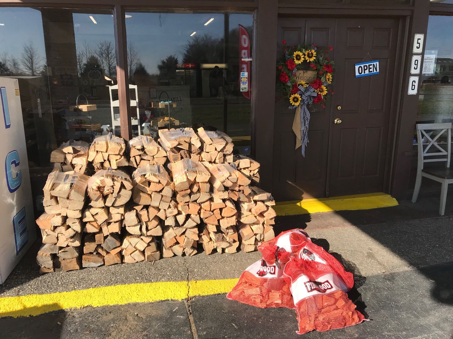 A pile of wood is sitting in front of a store.