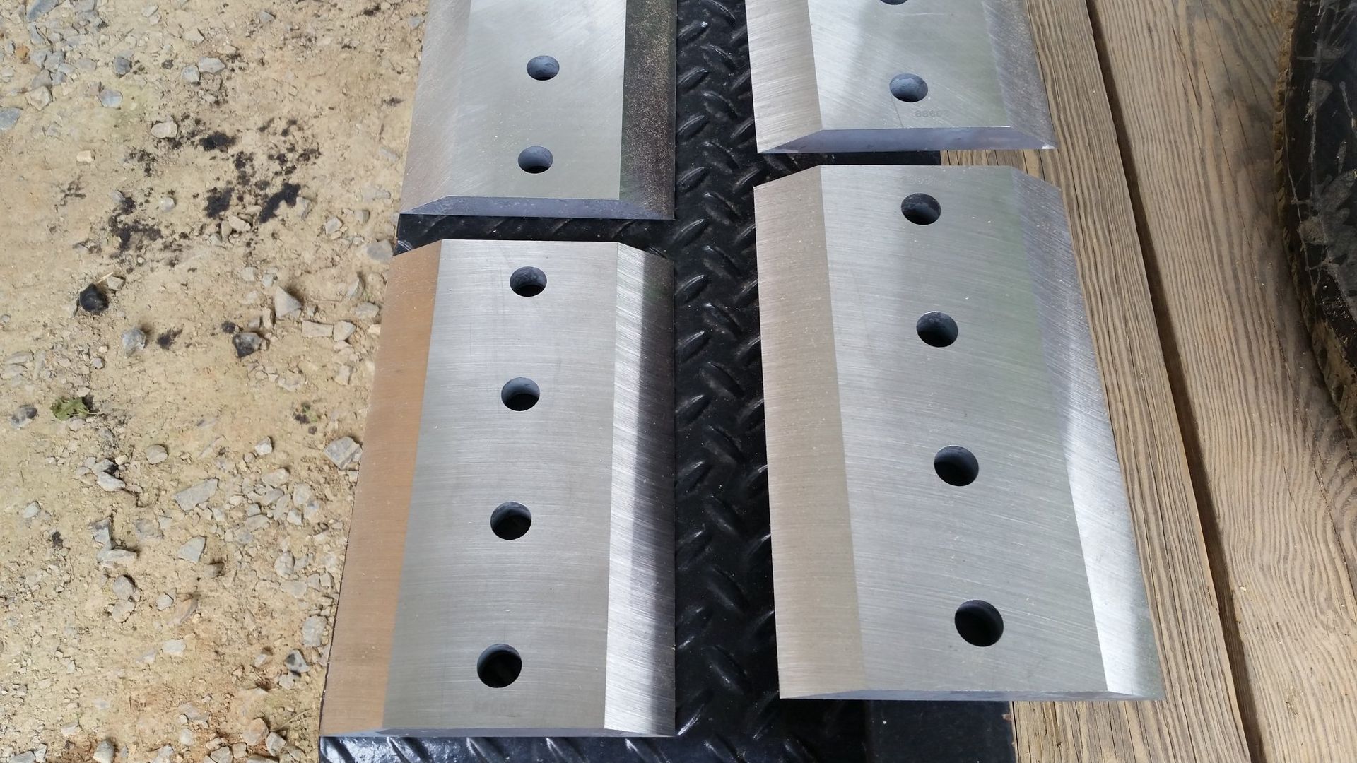 Three pieces of metal with holes in them are sitting on a table.