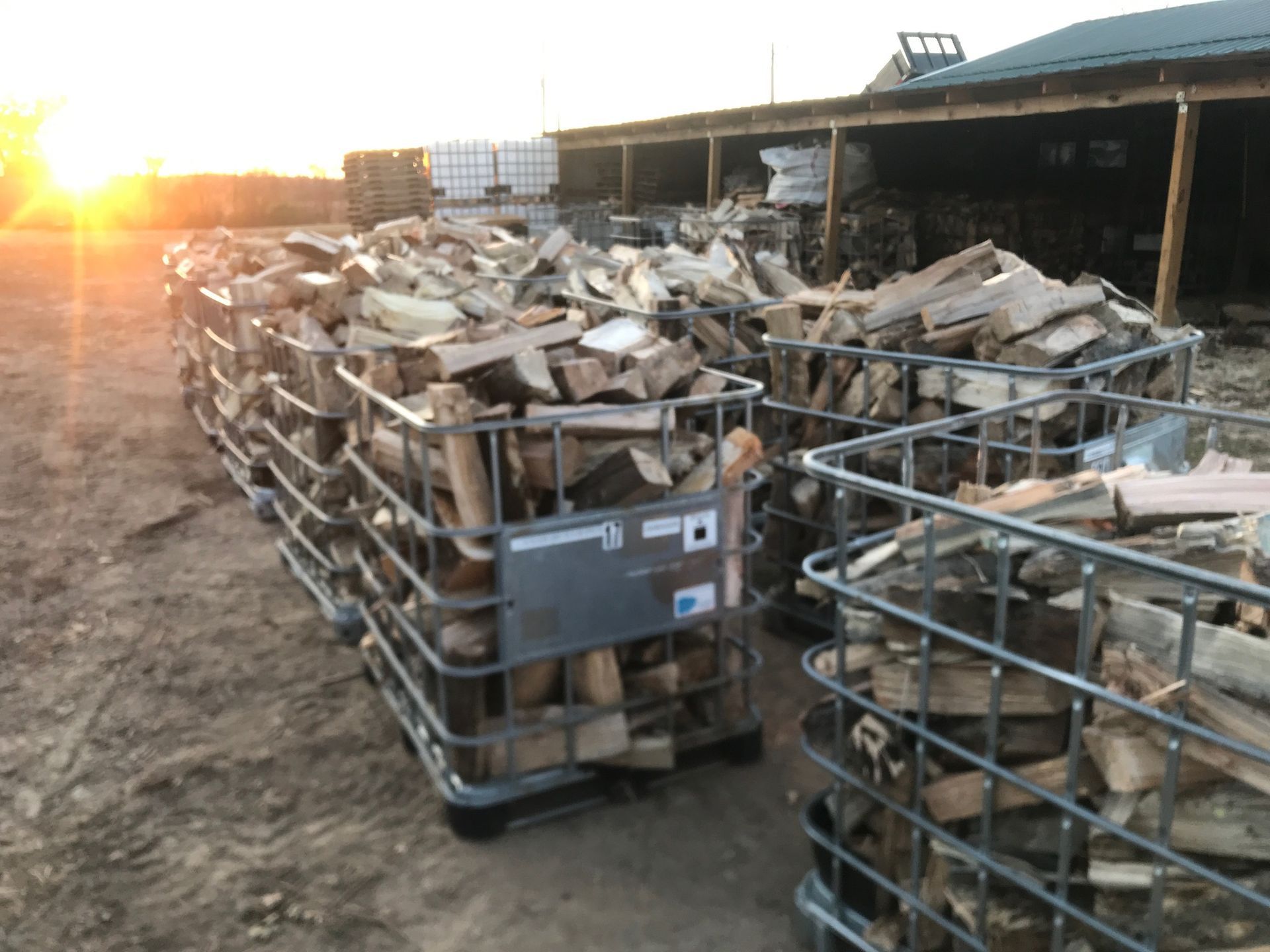 A bunch of crates filled with wood are sitting on the ground.