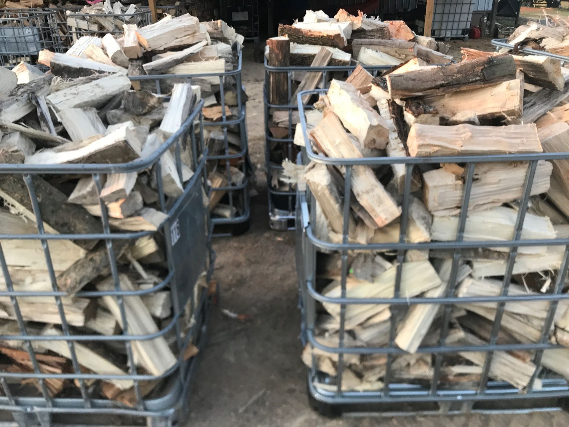Two metal crates filled with wood are sitting on the ground.