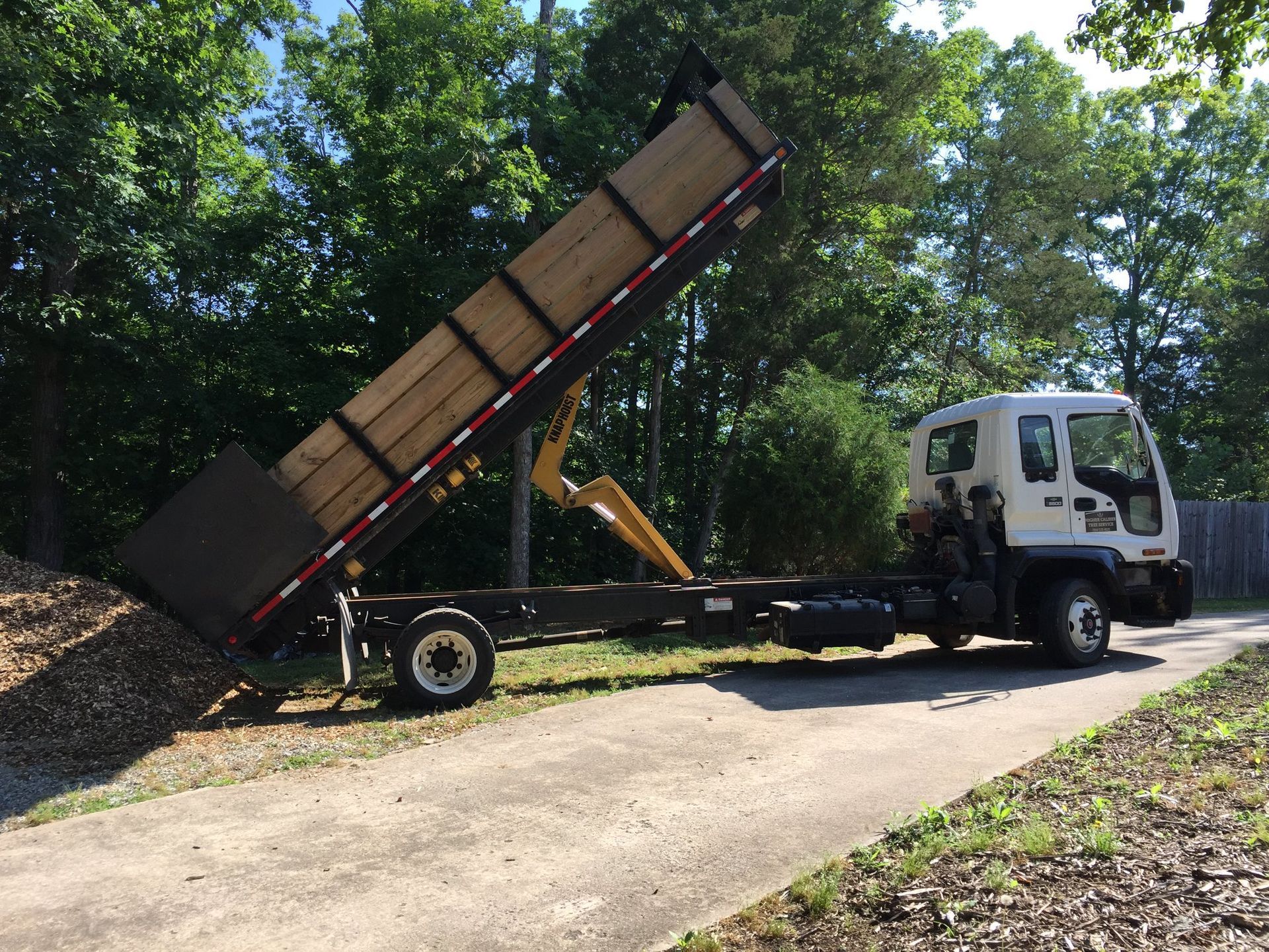 A dump truck is parked on the side of a road.