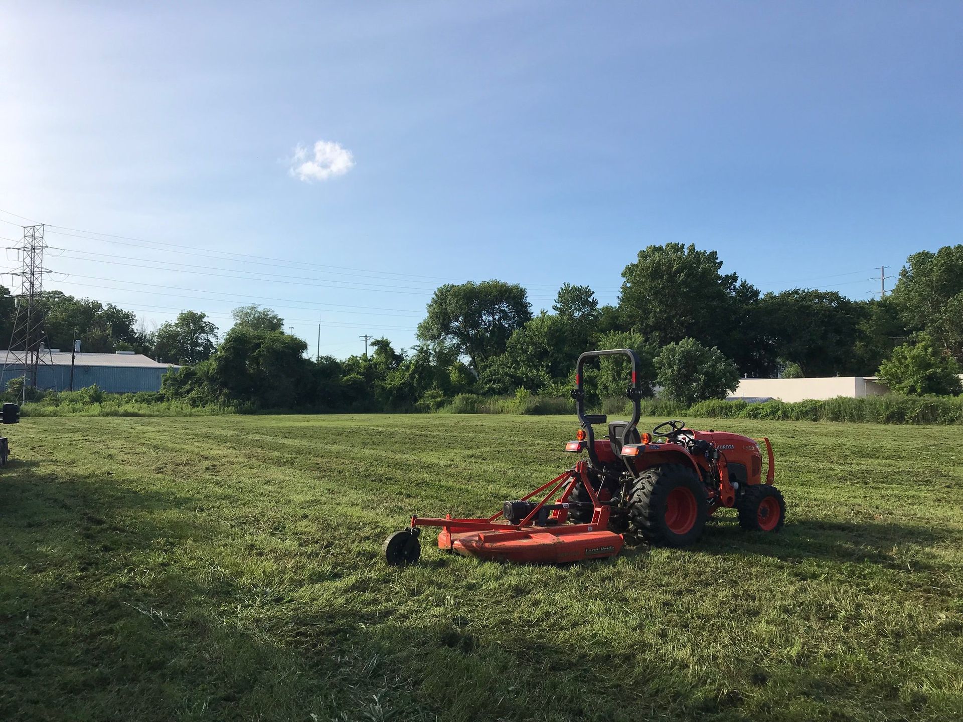 A tractor is cutting grass in a field.