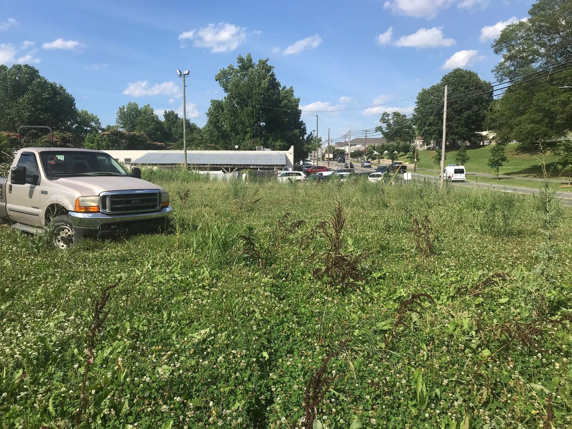 A white truck is parked in a grassy field.