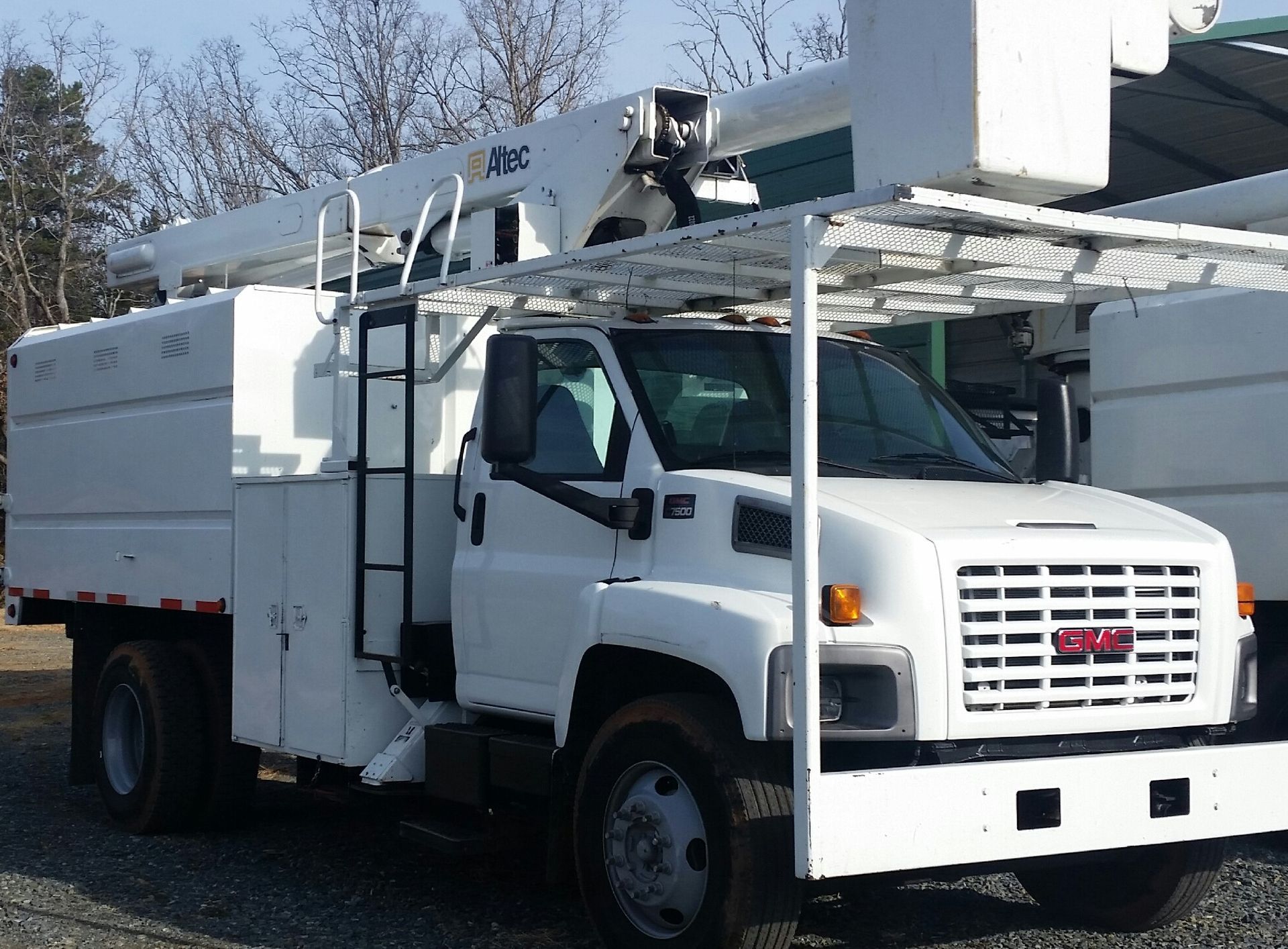 A white utility truck with a ladder on top of it