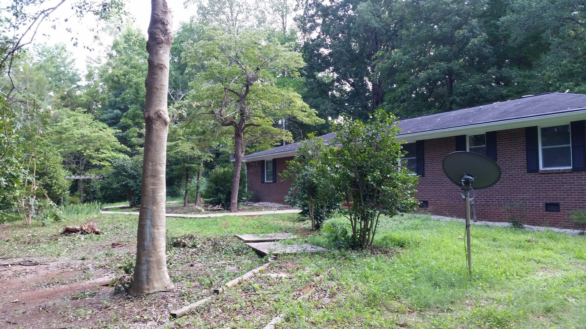 A brick house with a satellite dish in front of it