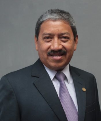 Ejecutivo de la empresa con traje y corbata sonríe para la cámara.