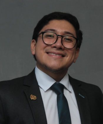 Ejecutivo de la empresa con traje y corbata sonríe para la cámara.