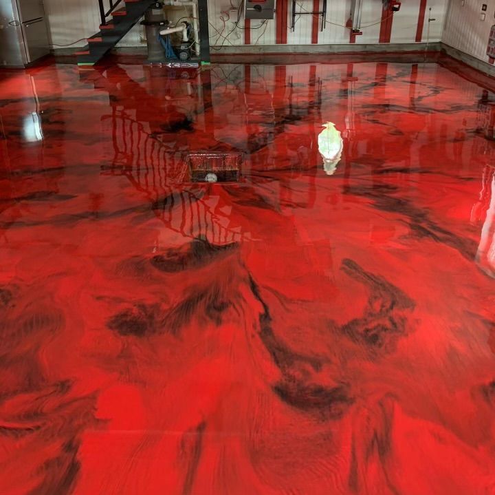 A red and black epoxy floor in a basement.
