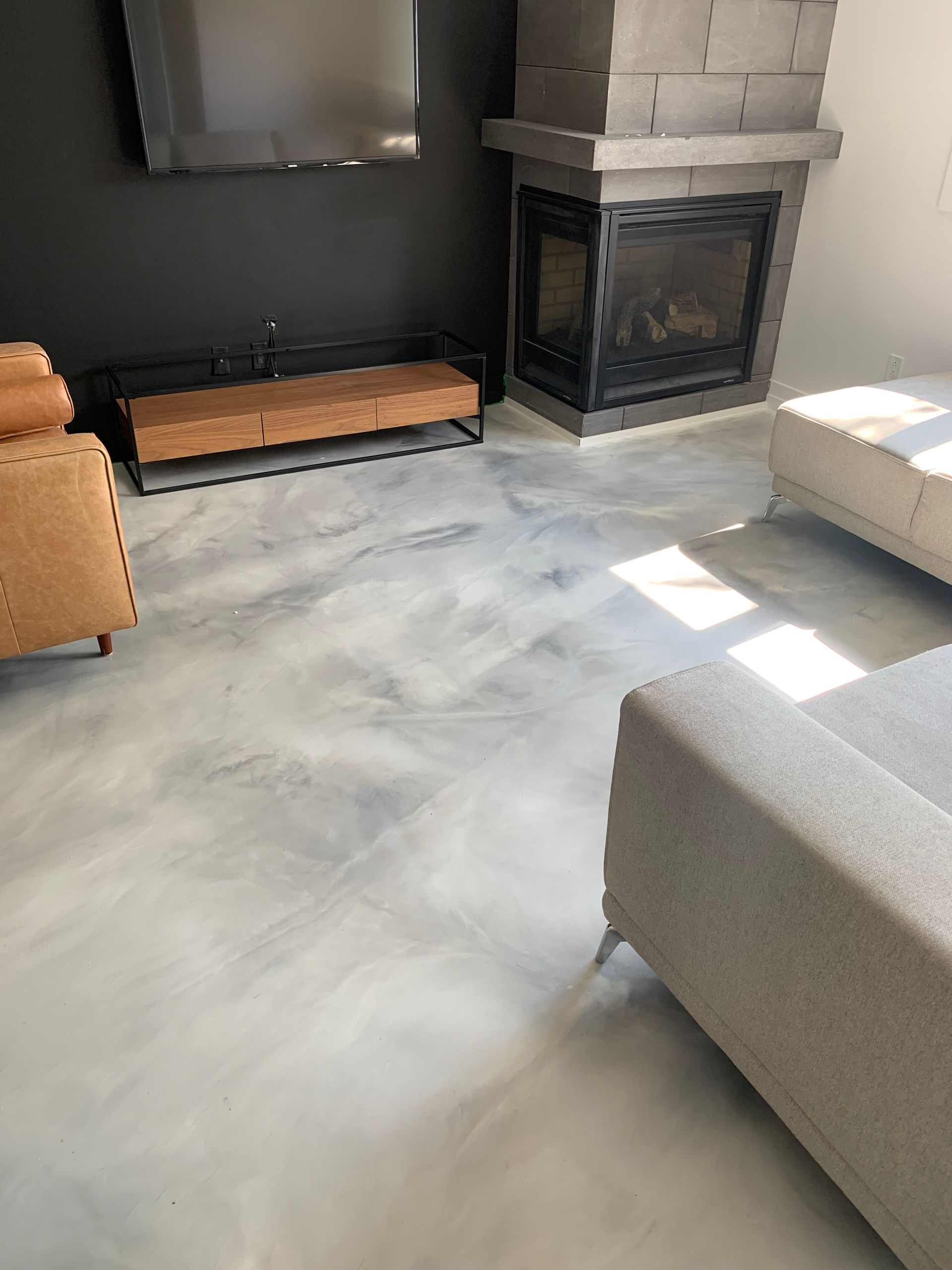 A living room with a fireplace , couch , chair and television.