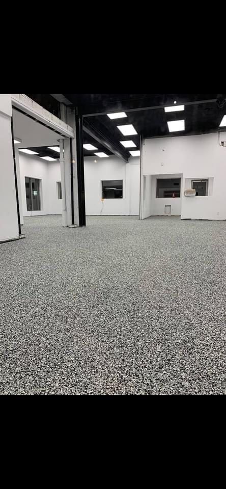 A large empty room with a gray floor and white walls.