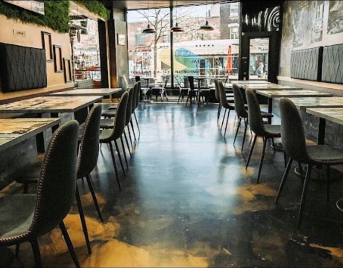 A restaurant with tables and chairs and a large window