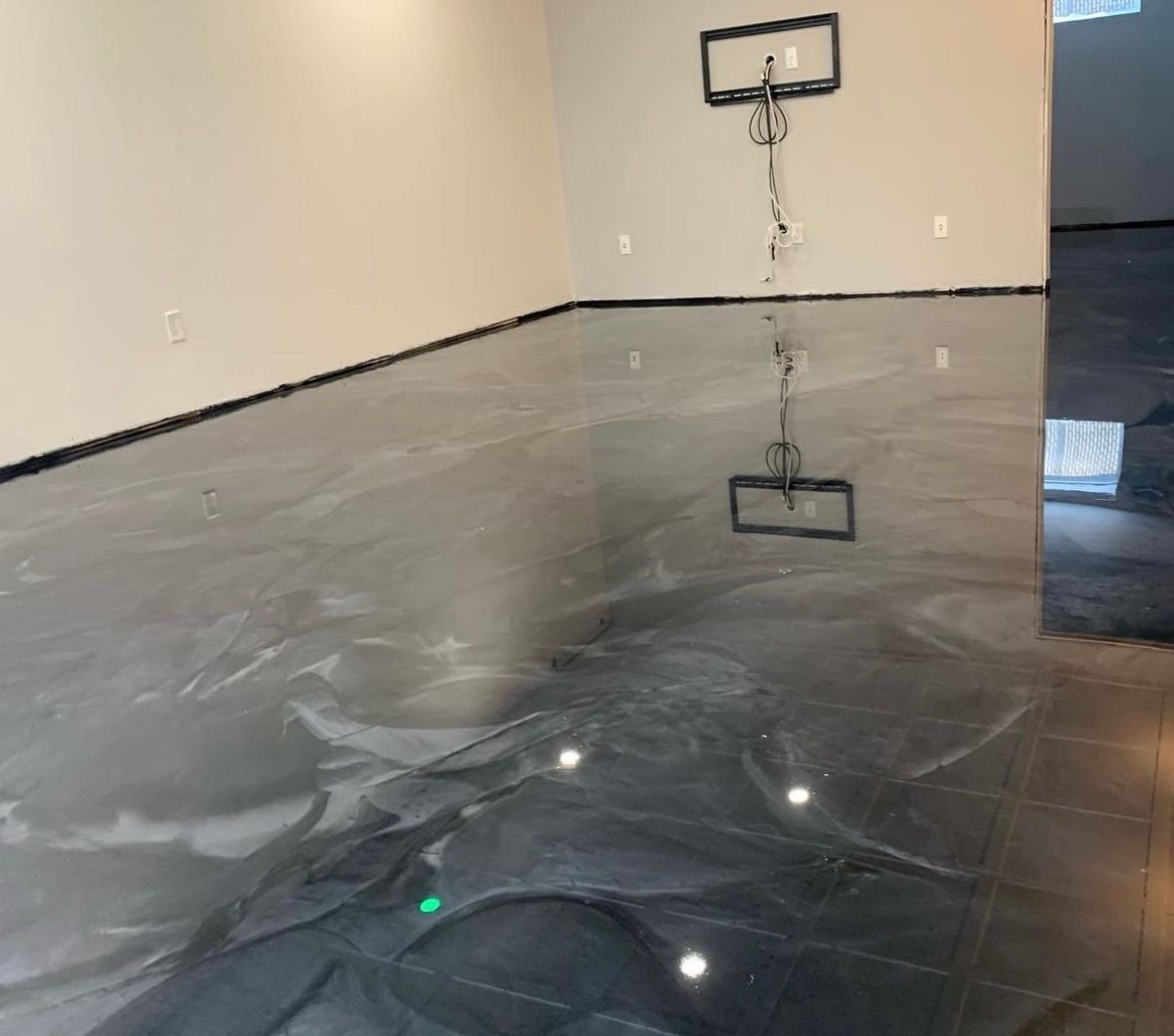 A room with a basketball hoop on the wall and a shiny floor.