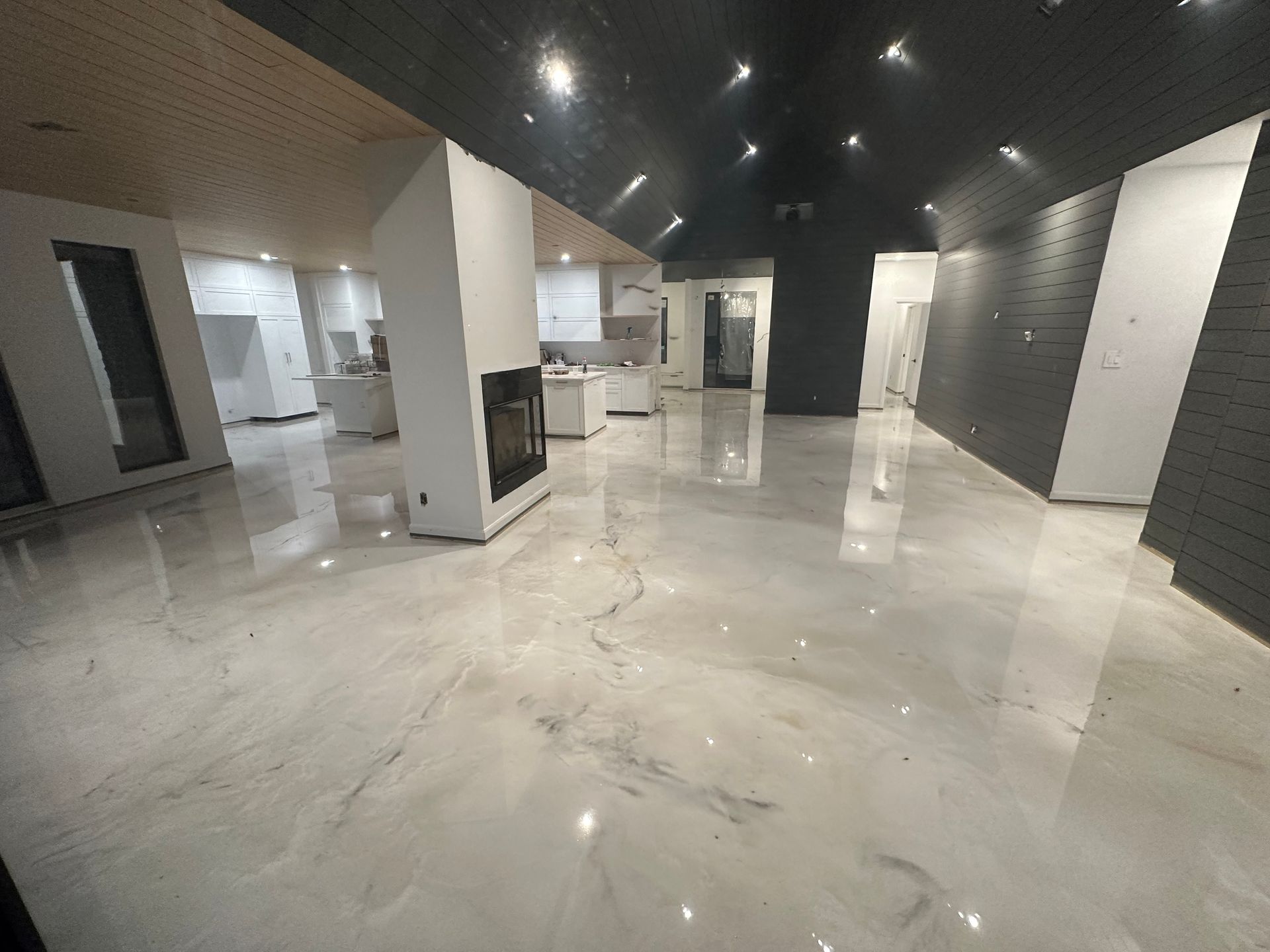 A large room with a marble floor and a fireplace.