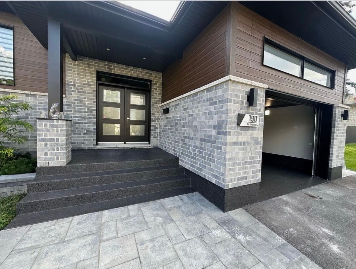 The front of a house with a garage and stairs leading up to it.