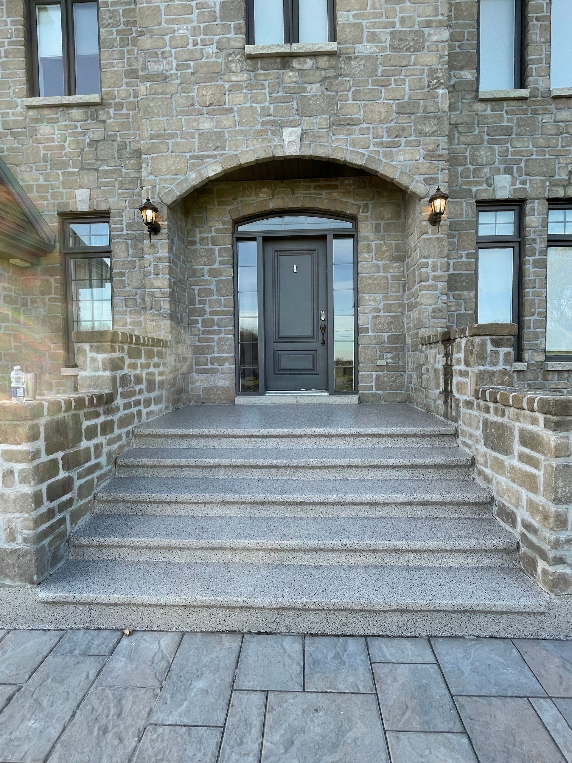 A brick building with a black door and steps leading to it.