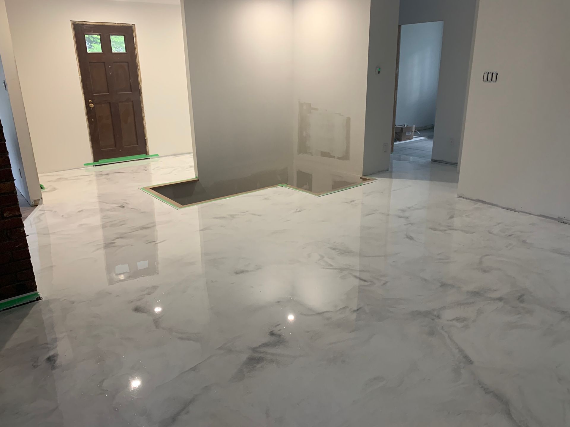 A white marble floor in a room with a door.