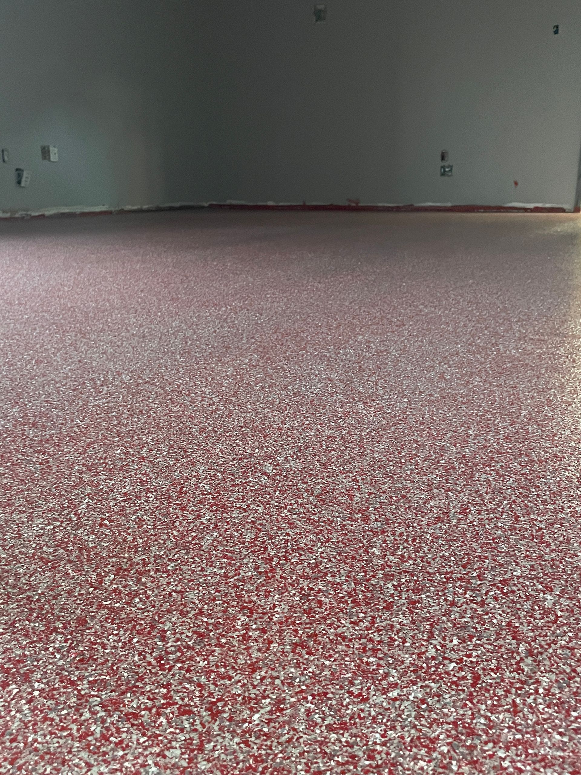 A close up of a red and white floor in a garage.