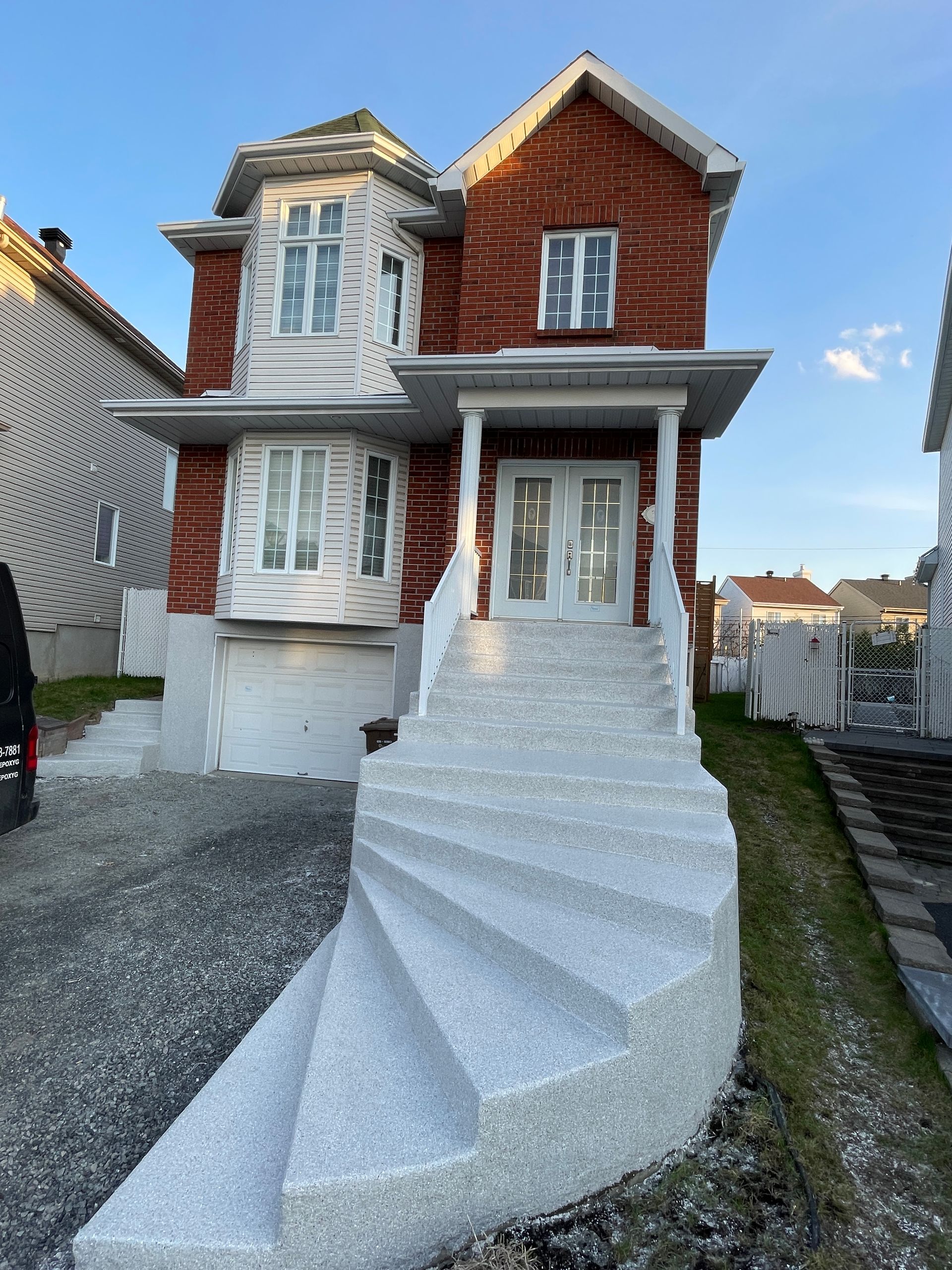 A brick house with a spiral staircase in front of it.
