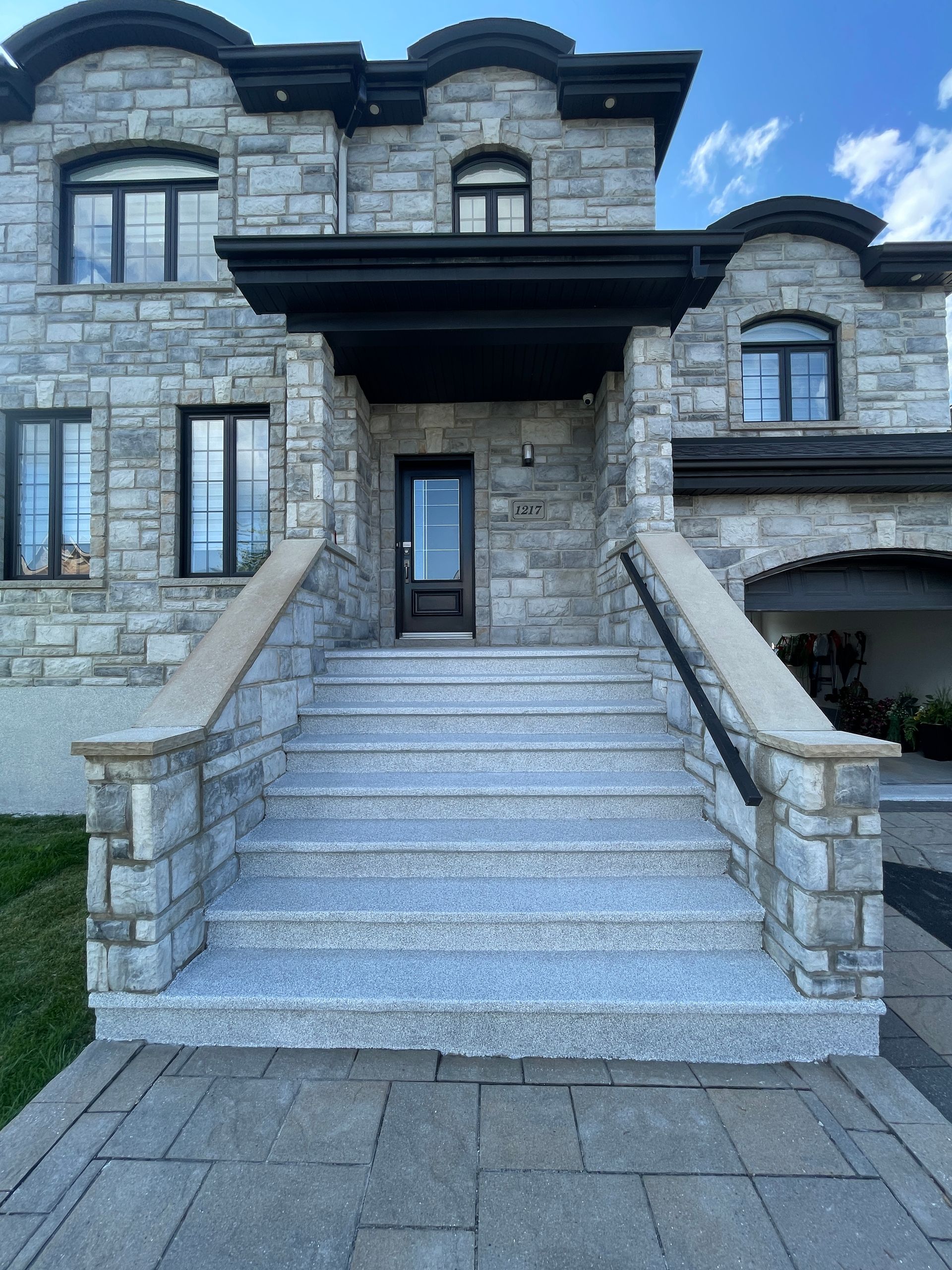 A stone house with stairs leading up to the front door