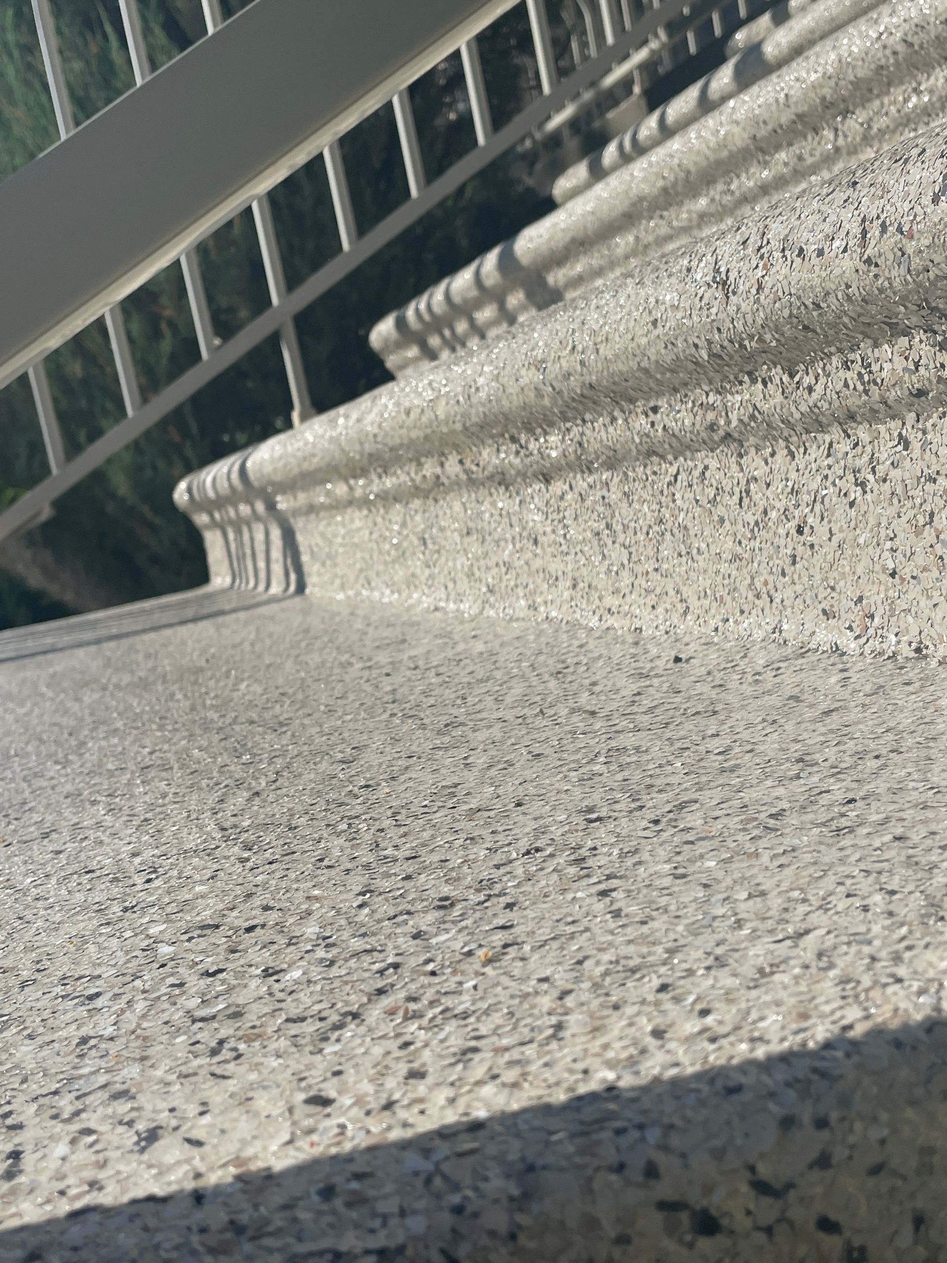 A close up of a staircase with a fence in the background.