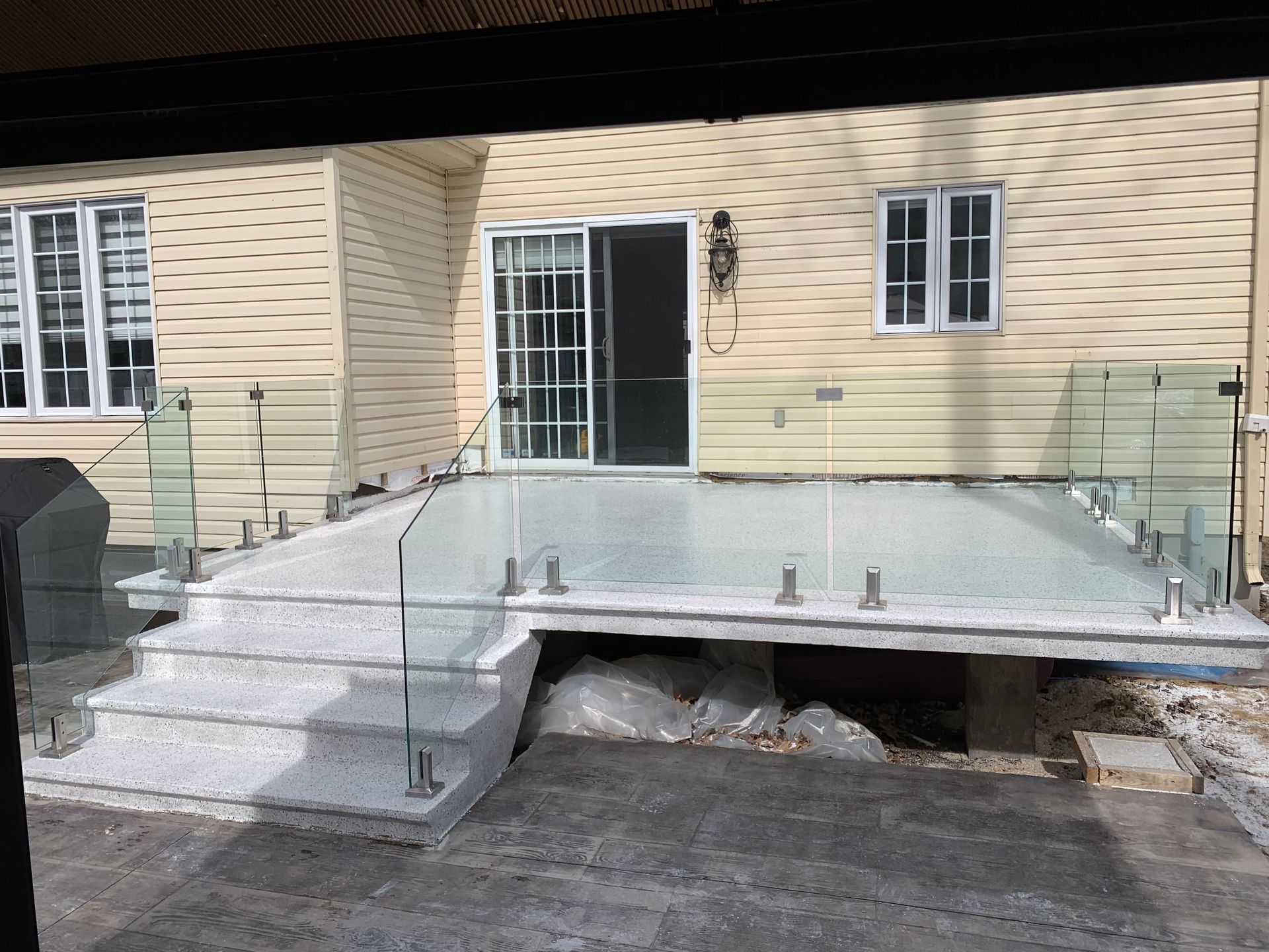 A house with a glass deck and stairs in front of it