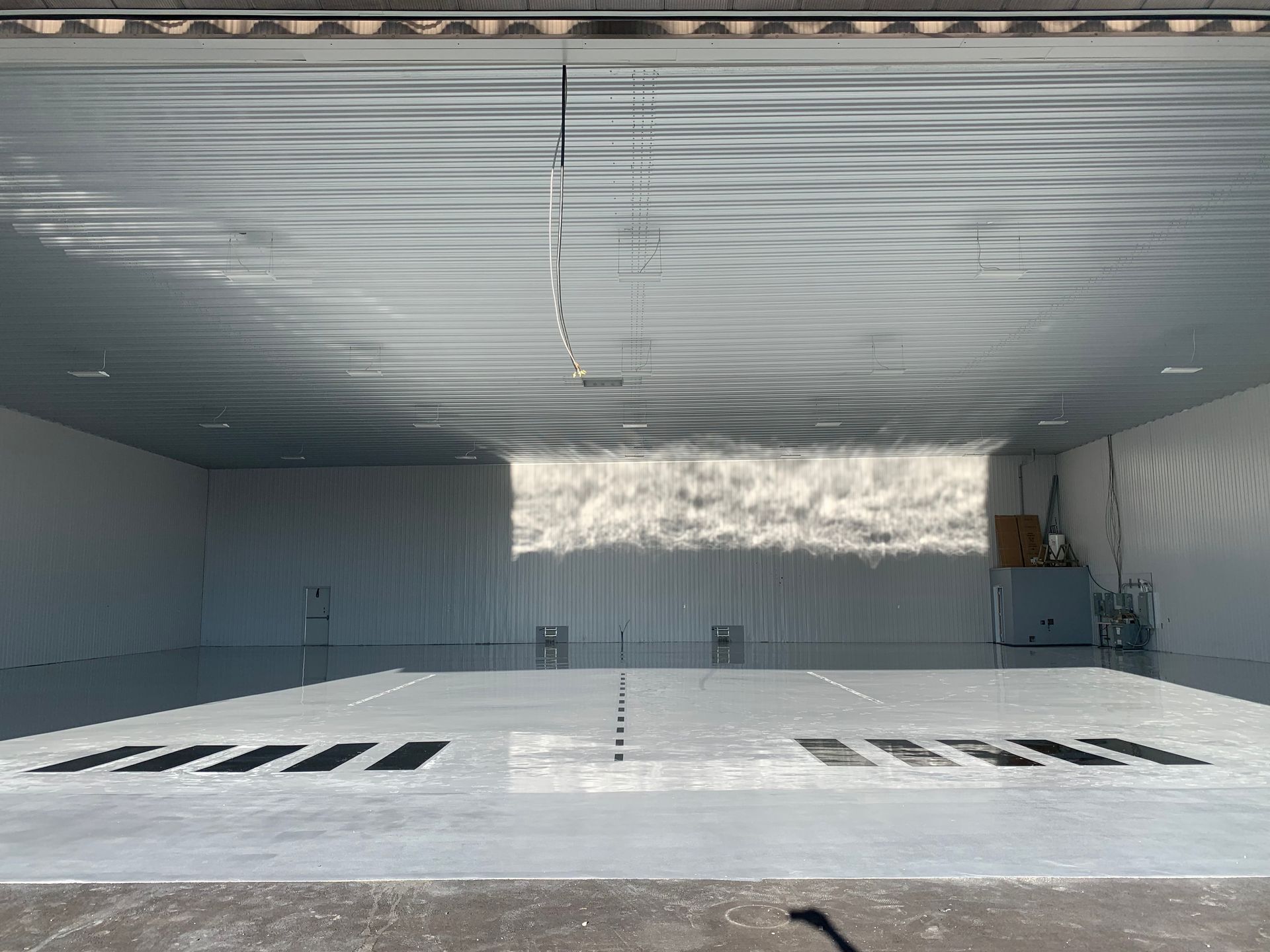 The inside of a building with a white floor and a window