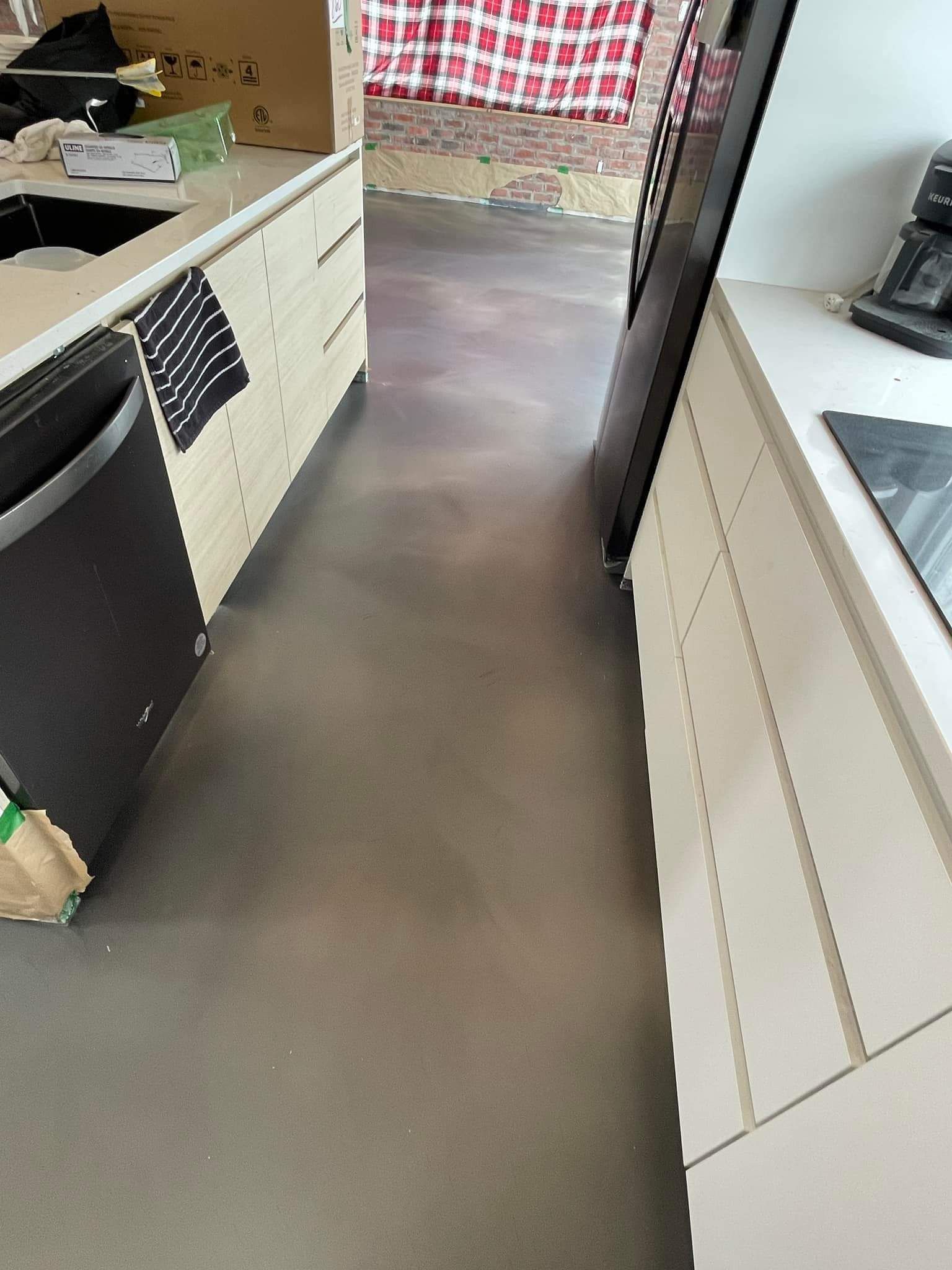 A kitchen with a gray floor and white cabinets