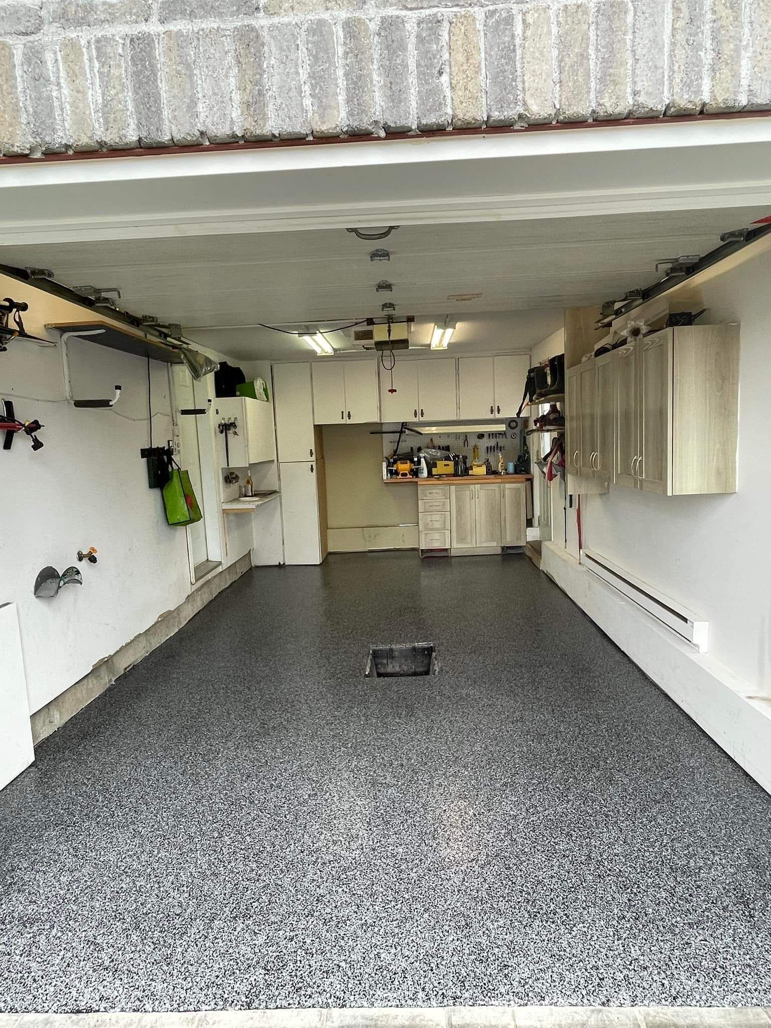 A garage with a gray and white floor and cabinets.