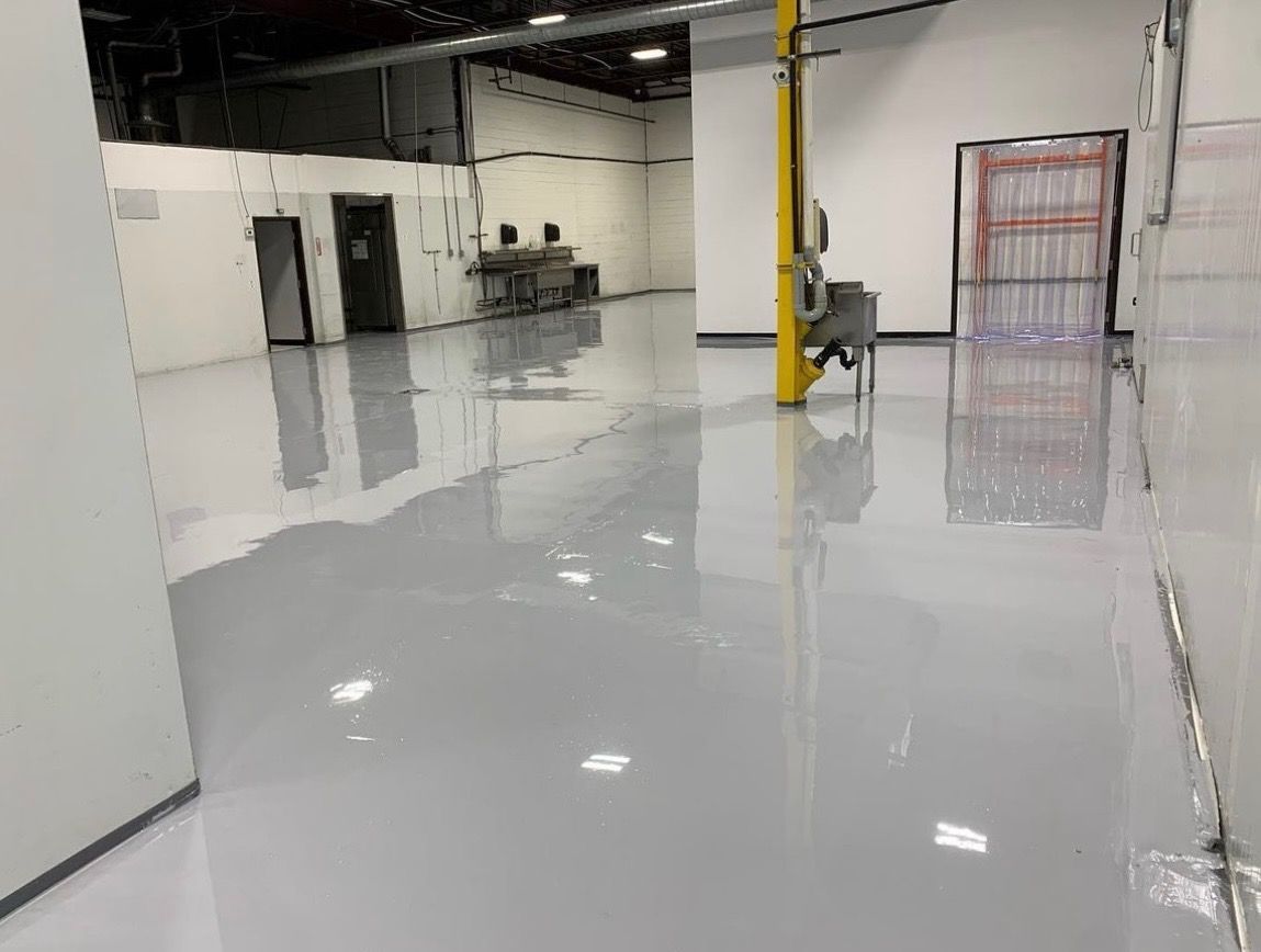 A large warehouse with a concrete floor and a yellow pole.