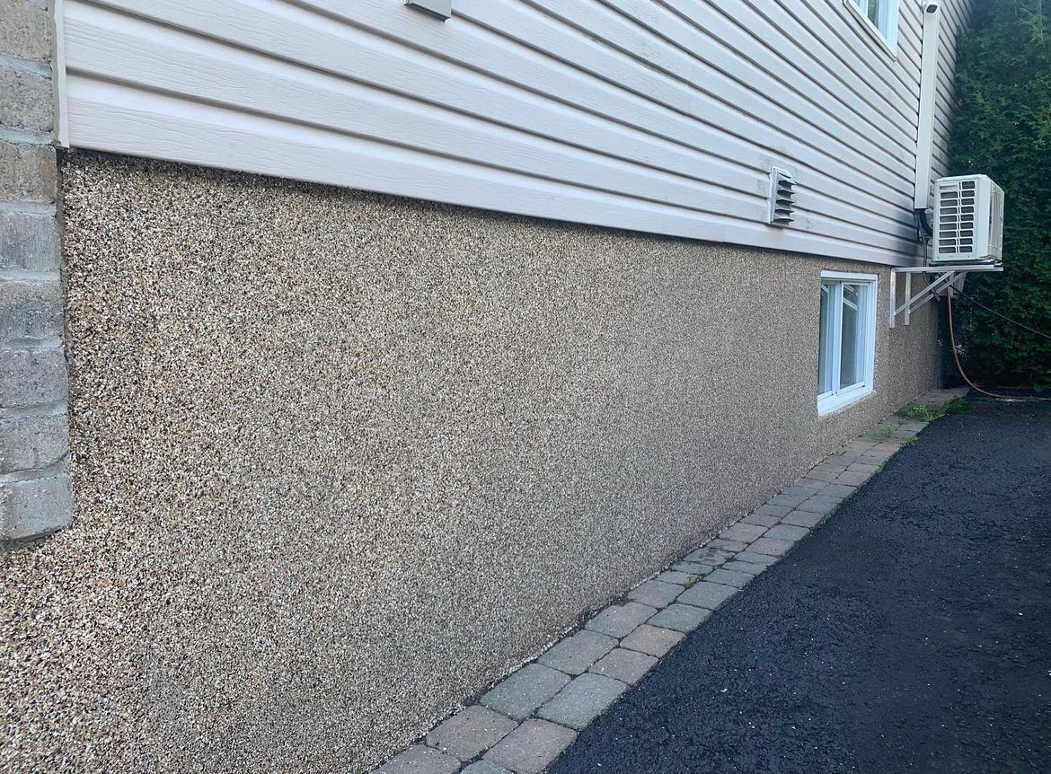 The side of a house with a driveway leading to it.