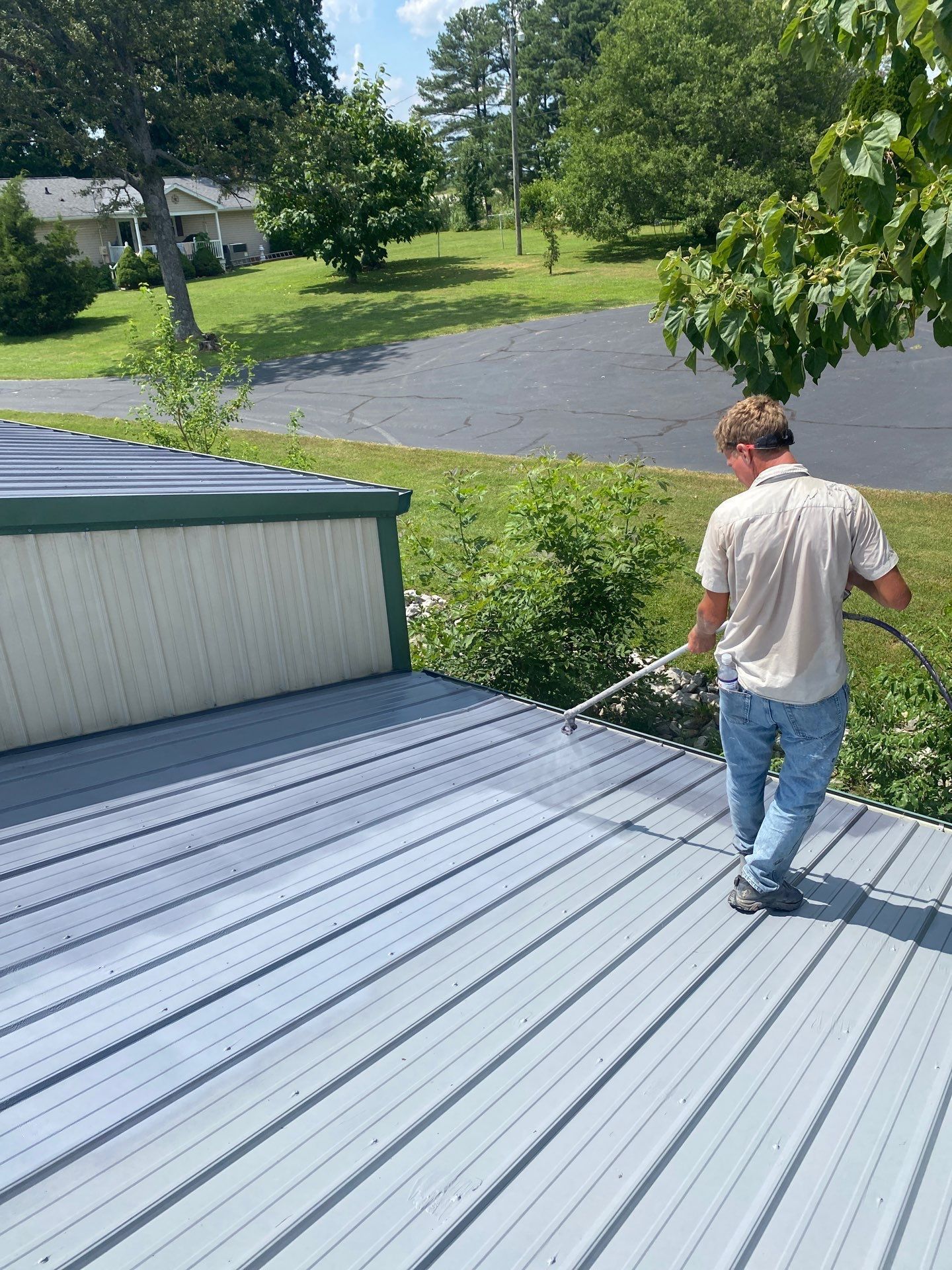 A man is spraying a deck with a hose.