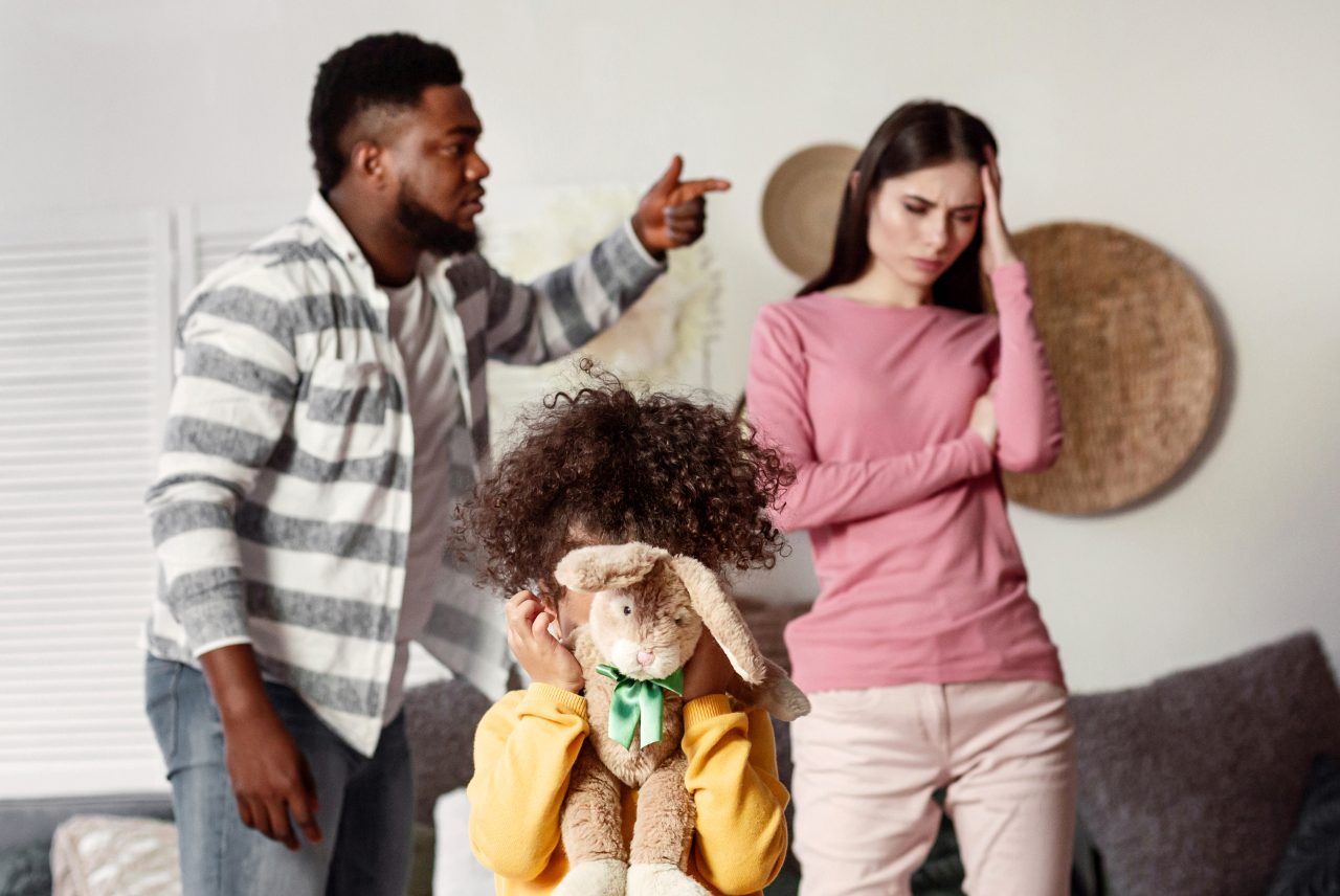 man and woman arguing with a small child crying