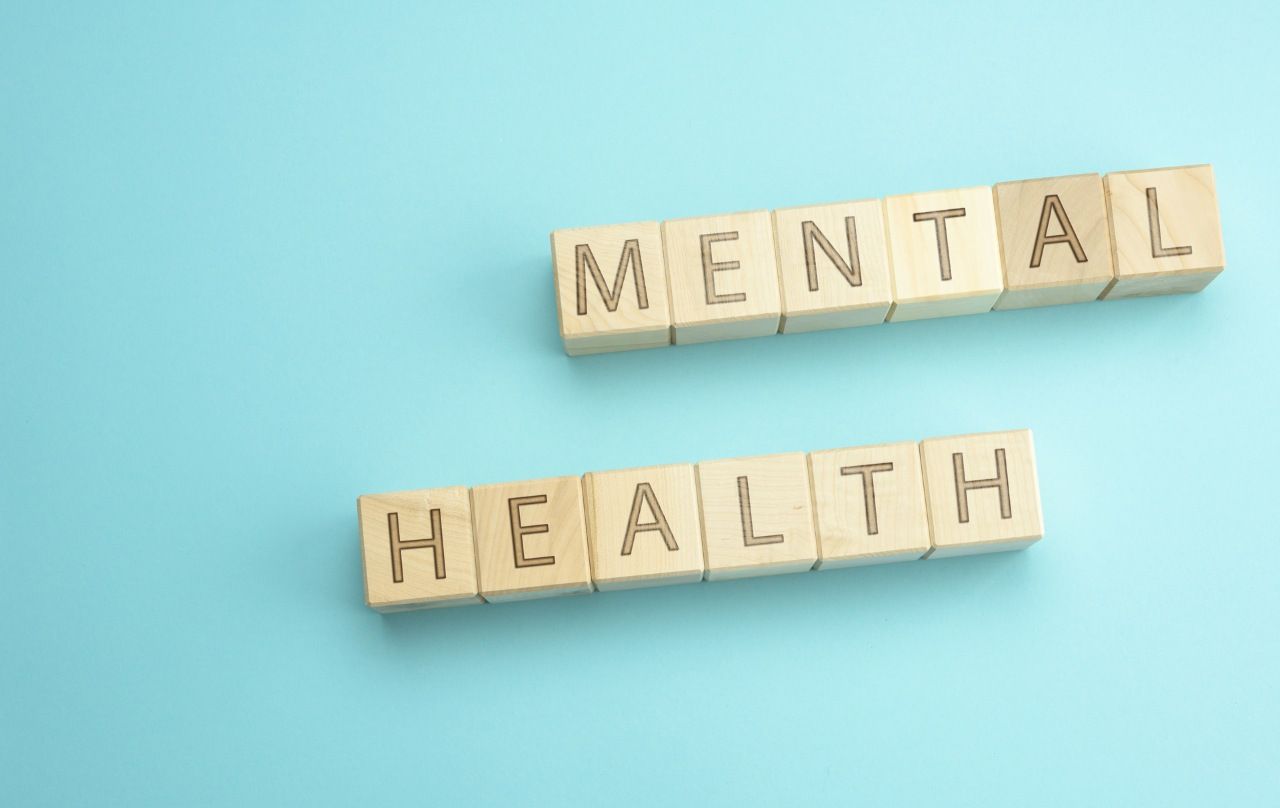words mental health spelled on wooden blocks on blue background