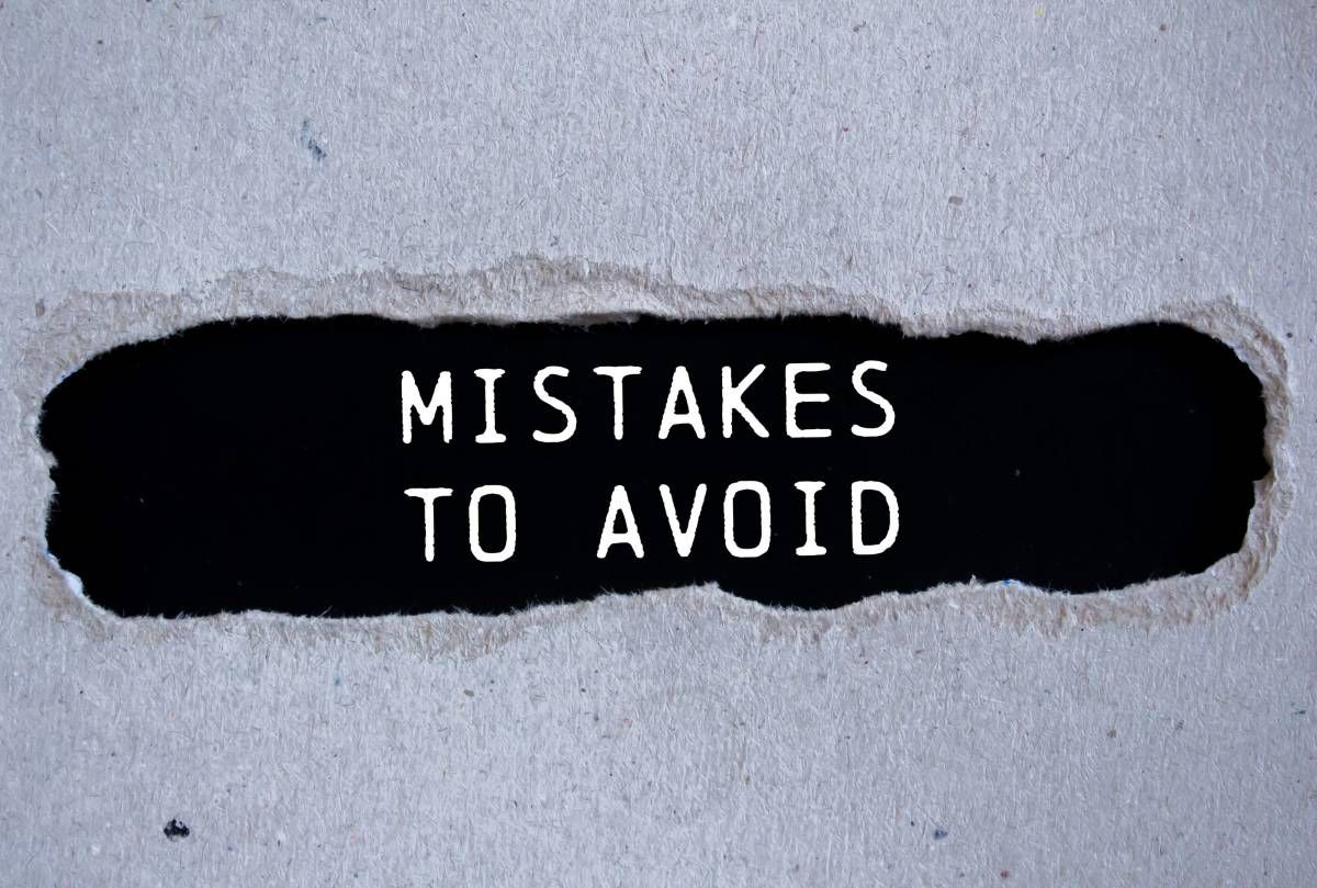 Mistakes to avoid message written on ripped torn gray paper with black background