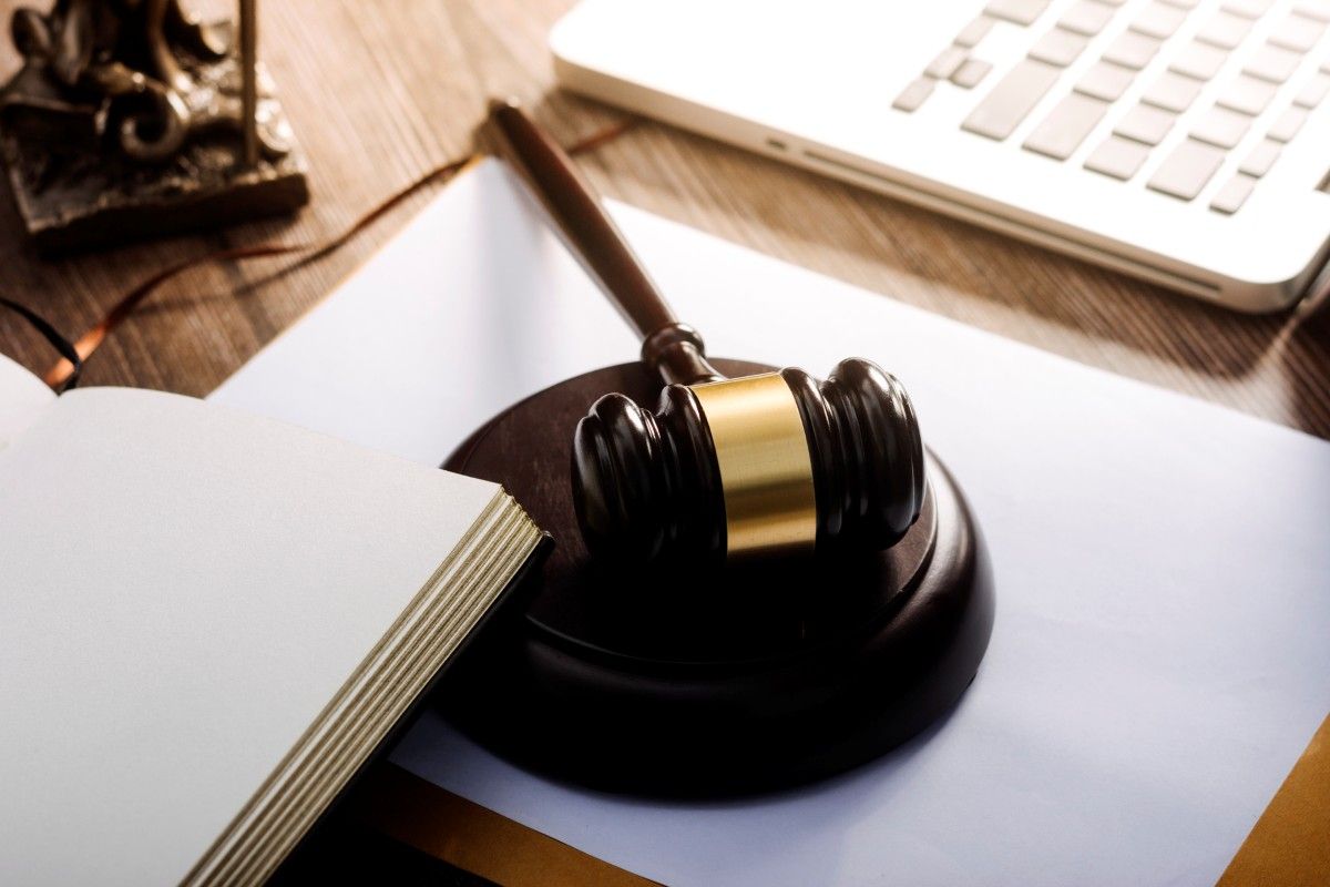 papers with brass scale and gavel on desk in office
