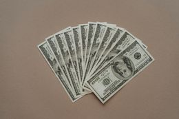 A fan of 100 dollar bills on a table.