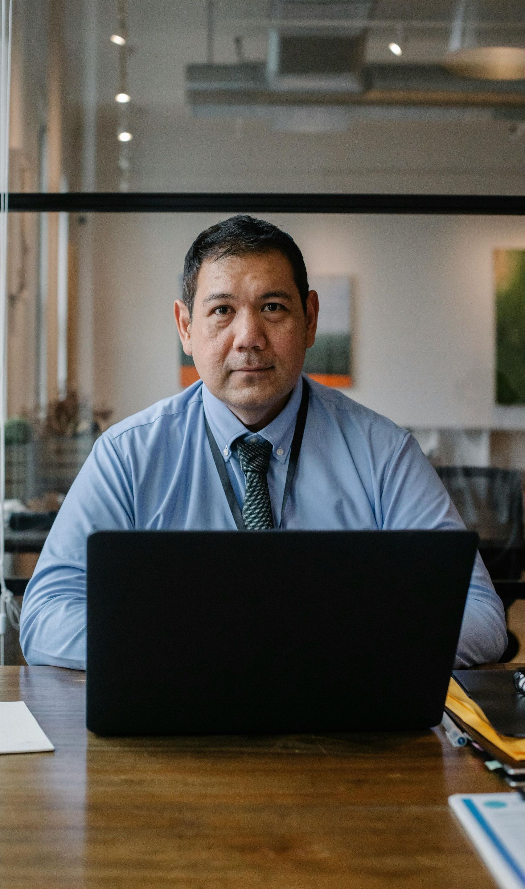 A man is sitting at a desk using a laptop computer.